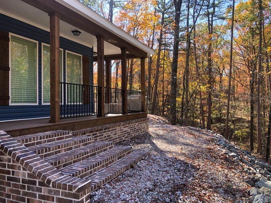 Discover a brand new modular home located just 1 mile from the stunning, crystal-clear Lake Ouachita. Set on a spacious 3.89-acre lot adorned with plenty of trees, a creek, this property is a true gem. Ample parking is available for everyone, including boats and recreational vehicles, all with no restrictions or monthly fees. The home boasts an open floor plan and a modern, updated kitchen featuring abundant storage, quartz countertops, and a farmhouse-style stainless steel sink and appliances. Luxury vinyl flooring flows throughout the space. The master bedroom is generously sized, offering beautiful views of the surrounding trees through windows that let in plenty of natural light. The master bath includes double vanities, a large soaking tub, and a tiled walk-in shower complete with a rain showerhead, alongside two separate walk-in closets. The second and third bedrooms are also spacious and equipped with walk-in closets. Additional features include a convenient switch at the hot water heater for easily disconnecting if you’re away for an extended period, ample storage in the laundry area, and access to a wrap-around deck from two areas.