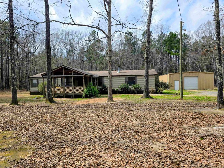 Welcome to your serene retreat!!  This spacious doublewide mobile home offers ample space, nestled on a 5 acre lot.  This home comes with a fully equipped kitchen featuring a refrigerator, and laundry room comes with a washer and dryer. The living room boasts a cozy wood burning fireplace.  Split floor plan.  All electric. Big front porch.  This property also features a 30x40 shop on concrete and roll up door, with 12' ceilings.  Perfect for workshop space for hobbies and projects. Experience the tranquility of rural living while still close to town.  Don't miss out on this fantastic opportunity to make this lovely mobile home your own.  Taxes are before Homestead Credit.  Call today for a tour!!