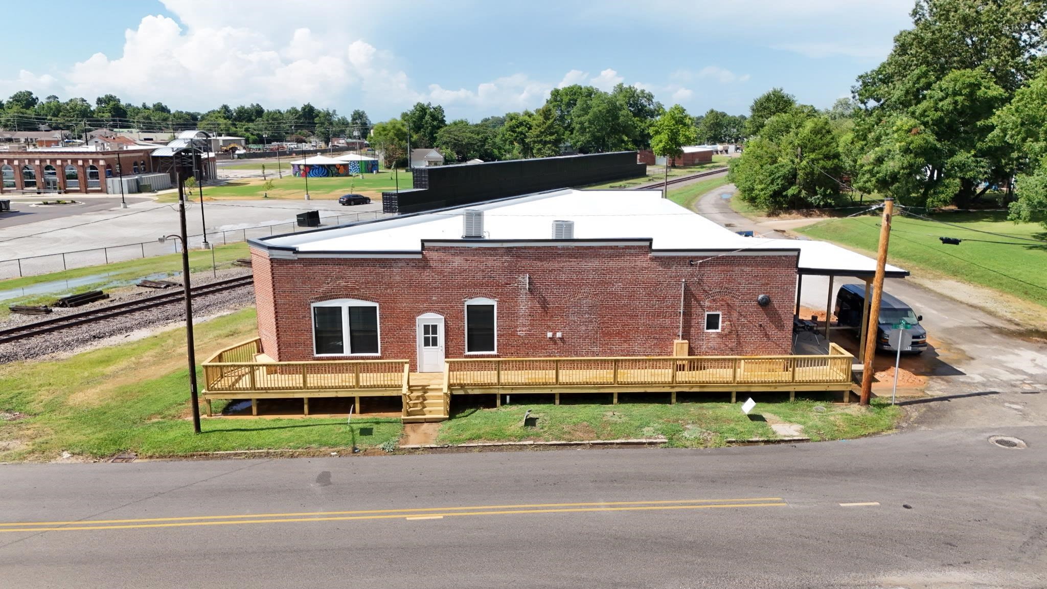 Paragould's Next Landmark Destination! Discover a one-of-a-kind opportunity in the heart of downtown Paragould with the Brick & Rail Building, 5,000 SF historic brick warehouse full of charm and potential, ideally located beside the railroad tracks and steps from local shops, dining, and entertainment. Right next to the Paragould Community Pavilion where the Farmers Market is held and the brand-new Station building, a redeveloped historic power plant, this versatile space features soaring ceilings, exposed brick, flexible open areas, a unique old vault room, two restrooms, utility room with mop sink and washer/dryer connection, plumbing for a kitchen and wet bar, gas tankless water heater, large storage room, garage side entry door, and a new wraparound deck for outdoor use. Zoned for commercial use with endless possibilities boutique retail, microbrewery, cafe, event venue, fitness studio, or space is ready to bring your concept to life in downtown Paragould's growing energy. New updates include hvac, TPO new roof, new deck, new baths, new flooring, lighting, and store front doors! Check out the vault in the cozy lounge room!