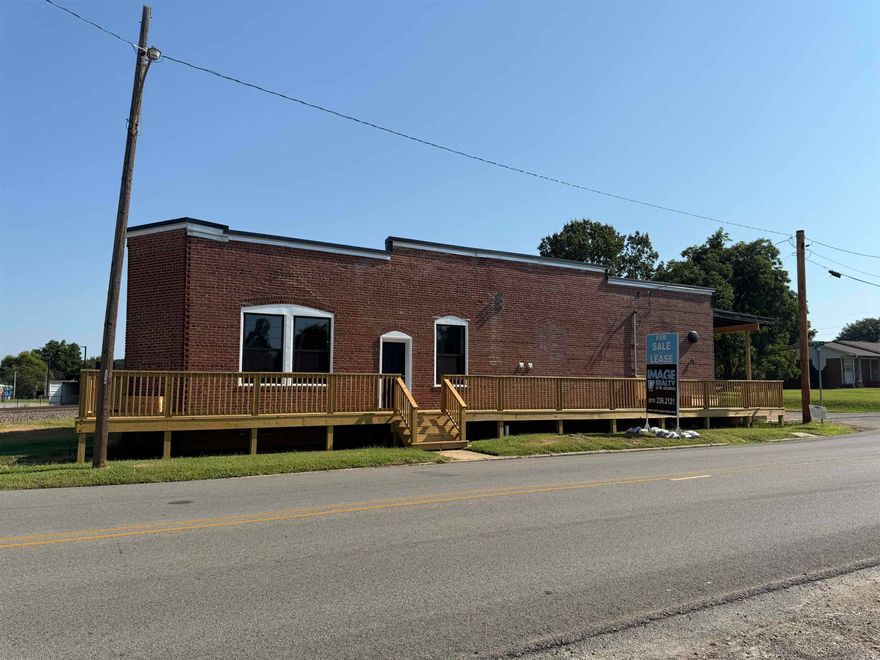 Discover a one-of-a-kind opportunity in the heart of downtown Paragould with the Brick & Rail Building, 5,000 SF historic brick warehouse full of charm and potential, ideally located beside the railroad tracks and steps from local shops, dining, and entertainment. Right next to the Paragould Community Pavilion where the Farmers PRICED BELOW RECENT APPRAISAL. Market is held and the brand-new Station building, a redeveloped historic power plant, this versatile space features soaring ceilings, exposed brick, flexible open areas, a unique old vault room, two restrooms, utility room with mop sink and washer/dryer connection, plumbing for a kitchen and wet bar, gas tankless water heater, large storage room, garage side entry door, and a new wraparound deck for outdoor use. Zoned for commercial use with endless possibilities boutique retail, microbrewery, cafe, event venue, fitness studio, or space is ready to bring your concept to life in downtown Paragould's growing energy. New updates include hvac, TPO new roof, new deck, new baths, new flooring, lighting, and store front doors!  Check out the vault in the cozy lounge room!