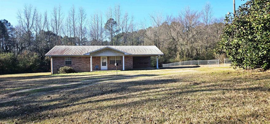 All Brick Home that sits on approximately 1.09 acres.  Home offers 3BR/2BA spacious closets in each room.  All electric, Metal Roof, Carport, and outside storage building.  Front of the land has a circle drive, and a portion of the land has been fenced in with a large gate area.  Agents see remarks