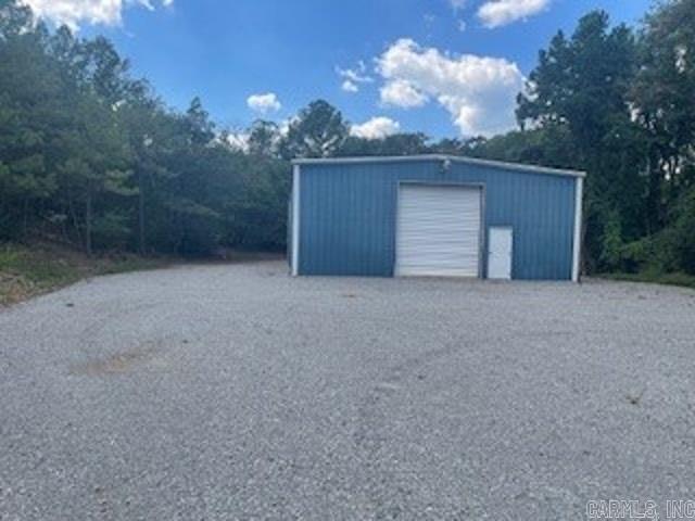 This 2,400 square foot commercial building offers a functional and versatile space ideal for a variety of business operations. Constructed with practicality in mind, the structure sits on over one acre of land, providing ample room for expansion, parking, storage, or outdoor operations. The buildingās layout includes an open interior with high ceilings, allowing for flexible use as a workshop, warehouse, showroom, or light manufacturing space. One of the key features is a large overhead door, perfect for accommodating vehicle access, deliveries, or loading and unloading of goods. This feature enhances operational efficiency, particularly for businesses requiring frequent shipments or handling of large equipment. Inside, the building includes a convenient half bath, offering essential facilities for staff or visitors without compromising on workspace. The structure is designed for durability and ease of maintenance, with concrete flooring and metal siding. The spacious lot surrounding the building allows for easy vehicle maneuverability, outdoor storage, or future development. Utilities such as electricity and water are available, and the property is easily accessible.