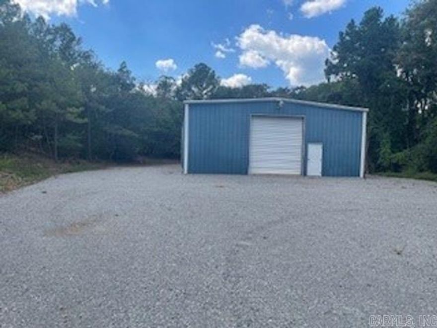 This 2,400 square foot commercial building offers a functional and versatile space ideal for a variety of business operations. Constructed with practicality in mind, the structure sits on over one acre of land, providing ample room for expansion, parking, storage, or outdoor operations. The building’s layout includes an open interior with high ceilings, allowing for flexible use as a workshop, warehouse, showroom, or light manufacturing space.  One of the key features is a large overhead door, perfect for accommodating vehicle access, deliveries, or loading and unloading of goods. This feature enhances operational efficiency, particularly for businesses requiring frequent shipments or handling of large equipment. Inside, the building includes a convenient half bath, offering essential facilities for staff or visitors without compromising on workspace.  The structure is designed for durability and ease of maintenance, with concrete flooring and metal siding. The spacious lot surrounding the building allows for easy vehicle maneuverability, outdoor storage, or future development. Utilities such as electricity and water are available, and the property is easily accessible.