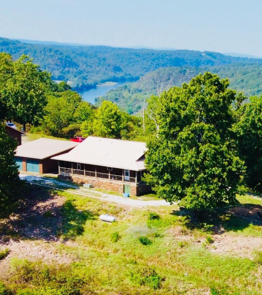Million-dollar view!!! Prepare to be completely captivated by a view worthy of being chosen as a cover photo to represent the mountainous beauty of world-renowned Mountain View! The panoramic views from this gorgeous 10+ acre mountaintop property stretch across mountains, valleys, & the glistening White River below! Large windows in the well-maintained cabin frame magnificent views with a spacious open concept design, blend of farmhouse & rustic charm, & the timeless warmth of rich wood walls & flooring. Start your days on the covered wraparound porch as the morning mist rises from the river & enjoy relaxing evenings watching bursts of orange across the sky & water as the sun sets over the valley below. One detached garage has 4 garage doors with plenty of space for a workshop, home office, collectables, etc. A second detached garage has been uniquely converted into living quarters perfect for guests, in-law quarters, or for use as a nightly rental with a bedroom, full bath, & large kitchen/living combo plus a spacious loft to be finished for additional living space if needed. Beautiful, move-in ready, less than 2 miles to launch your boat for White River fishing, priced to sell!