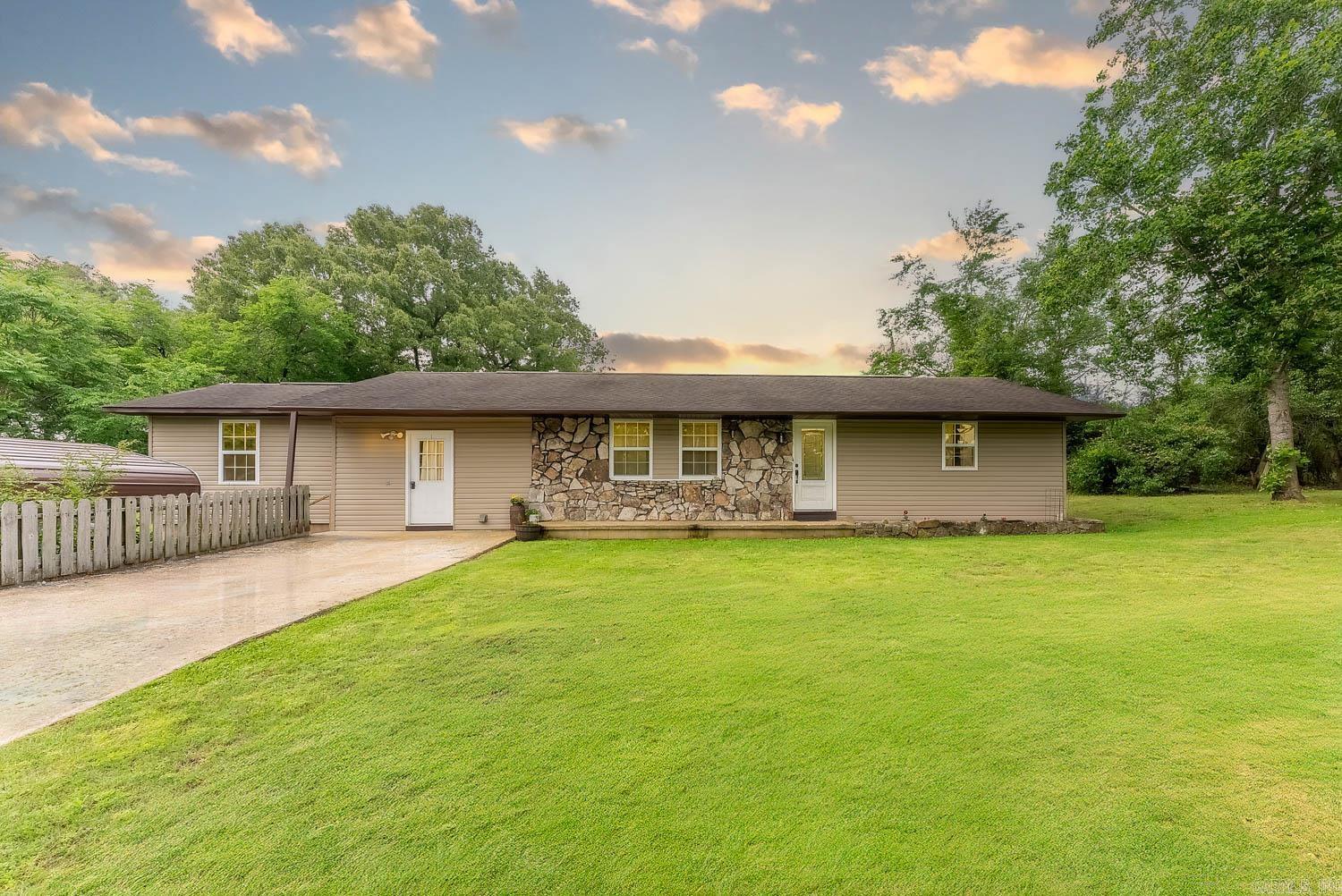 Ozarks hobby farm on 4.86+/- acres just outside Mammoth Spring! This 3-bed, 2-bath home offers peaceful country living near town amenities. The land is fenced with a private pond, chicken coop, and multiple outbuildings—including a large shop with electricity. Inside, enjoy an updated kitchen with modern finishes and included appliances. The home features a partial unfinished basement with outside access—great for storage or a storm shelter. The primary suite includes a Queen Bedroom Set that can stay, and living room couches are also available. Outdoors, find improved fencing, landscaping, and exterior lighting. The fenced backyard is ideal for pets or kids. Located on a quiet dead-end road in Fulton County, Arkansas, this property is close to the Spring River—famous for fishing, floating, and recreation. Whether you're looking for a weekend retreat or full-time residence, this charming hobby farm offers comfort, convenience, and that perfect Ozarks lifestyle.