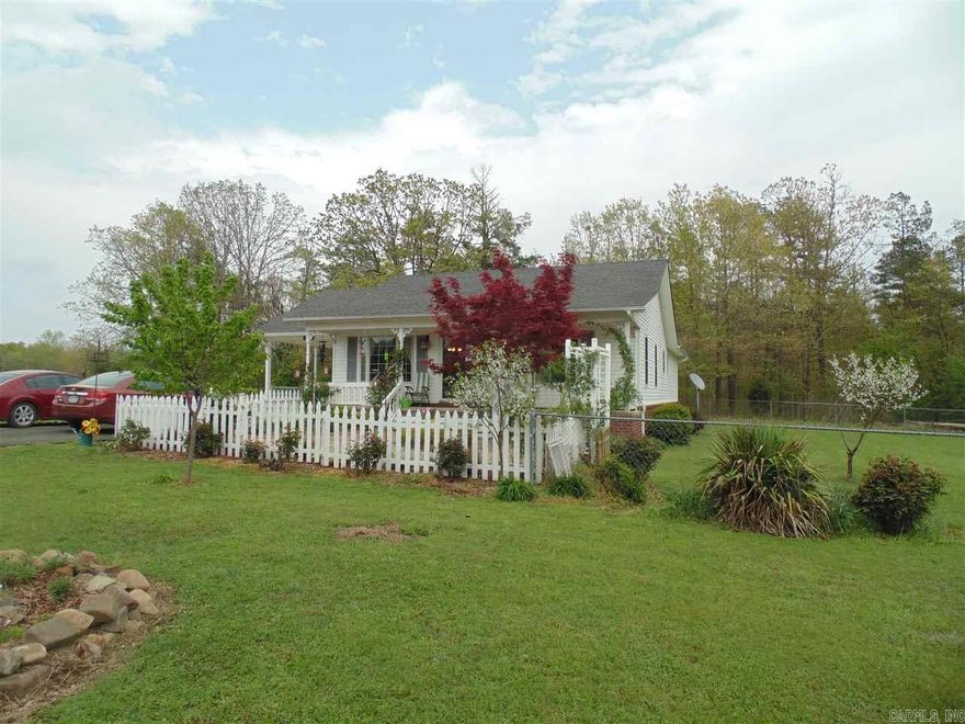 What a PLACE!!!  This cute cottage is just what the flower lover ordered.  Precious house with hardwood and laminate flooring, cathedral ceiling in the great room, open kitchen, large laundry, updated bathrooms, new windows and doors, large covered porch with fenced back & side yard.  Front yard offers, fish pond, muscadine vines, rose garden, white picket fenced front area and newly asphalted driveway.  A total MUST SEE & CALL HOME property!