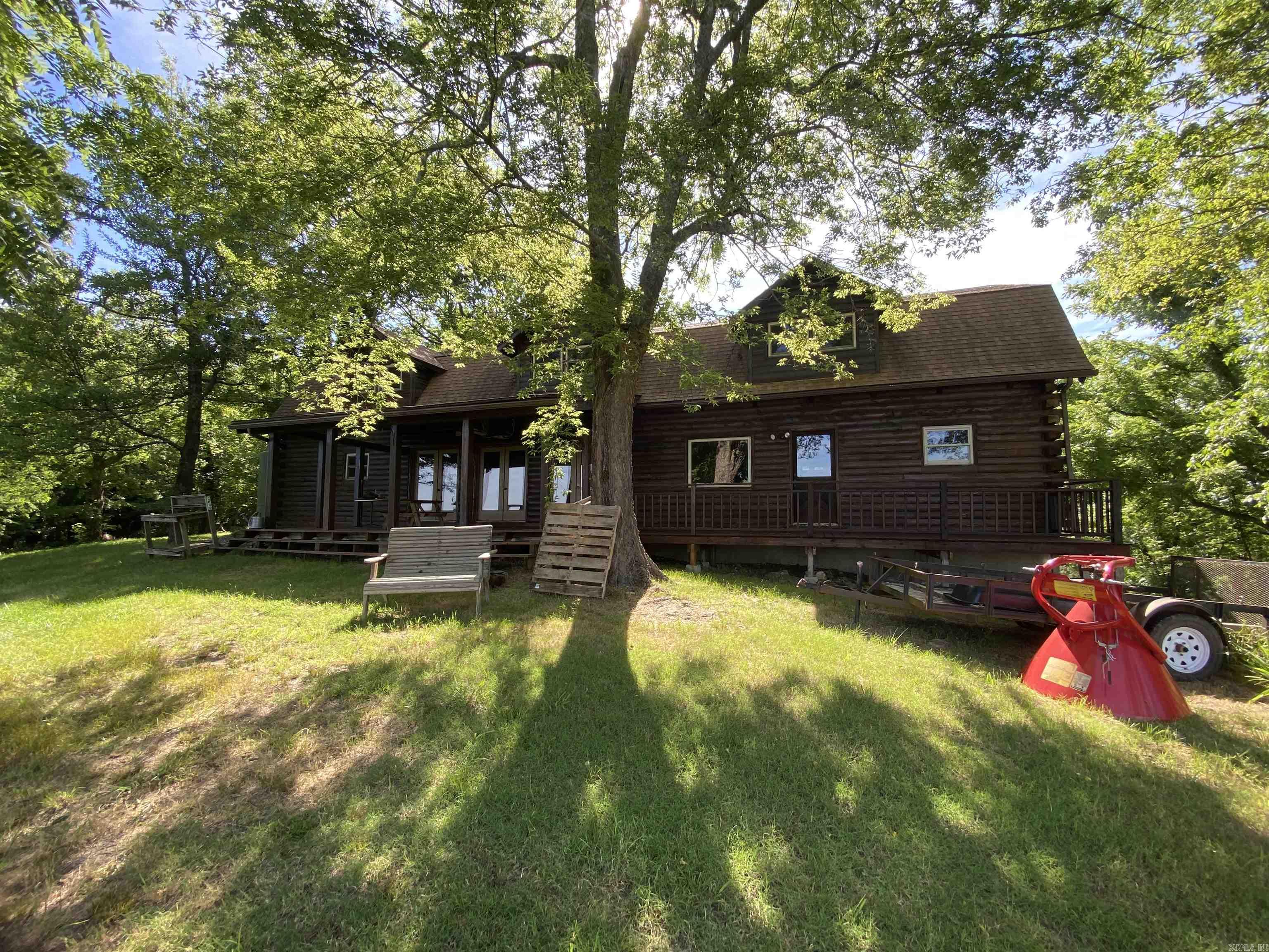 7 bedroom, 4.5 bath, 2 car garage, 2 fireplaces and much more with this 3,484 sq ft log cabin.  WOW. What a spread. 1,323 acres of timber, creeks and wildlife. Roads all thru the property make it great for riding 4 wheelers or side x sides. Plenty of food plots for the deer. Even a view of White River in some places.  Would make a great hunting lodge, place to get away or permanent residents. Lots of possibilities. Close to Mountain View, Anglers Cafe and Jo Jo's Catfish Wharf. Mineral rights convey.
