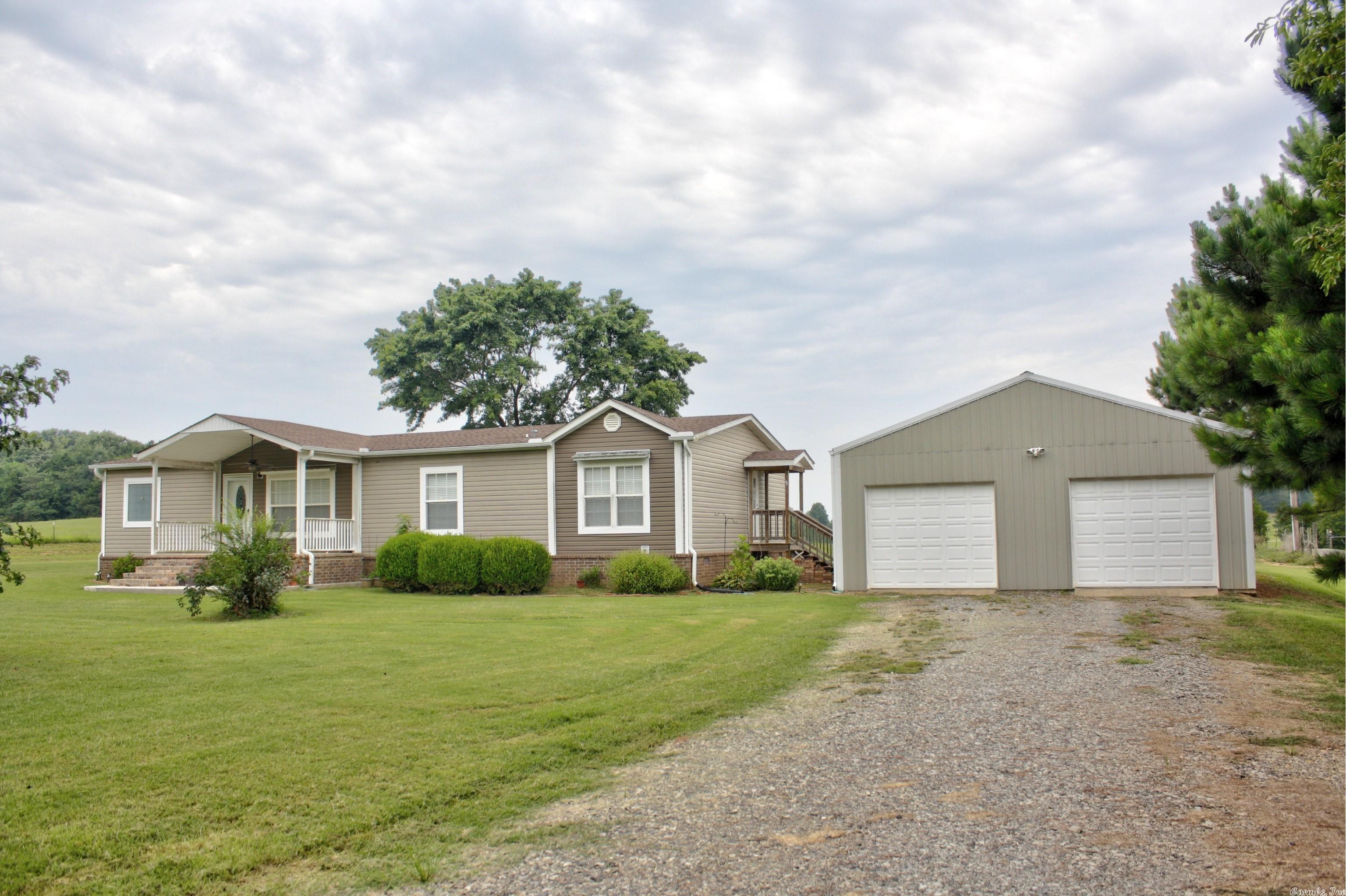 Yes, it’s a manufactured home, but it’s not your average or even above average double wide. This immaculate home is situated on a permanent foundation with a beautiful brick underpinning, sitting on 2 acres with a spacious 30' x 50' detached garage/shop boasting 10' sidewalls, insulation, and dual roll-up doors with openers. This versatile space is perfect for storing vehicles, tools, and pursuing various hobbies. Inside, the kitchen boasts a large breakfast bar and island, providing plenty of space for cooking or casual dining while the adjacent dining space has room for more of a sit down dining experience. The primary bedroom suite impresses with a step-in shower, a luxurious soaker tub, a double sink vanity, and a walk-in closet, offering a private retreat within the home. Step outside and enjoy the tranquility from either the covered back porch or the easterly facing front porch, perfect for hosting gatherings or simply relaxing after a long day. Sorry, there’s no garden this year but the perfect spot awaits your green thumb in the spring.