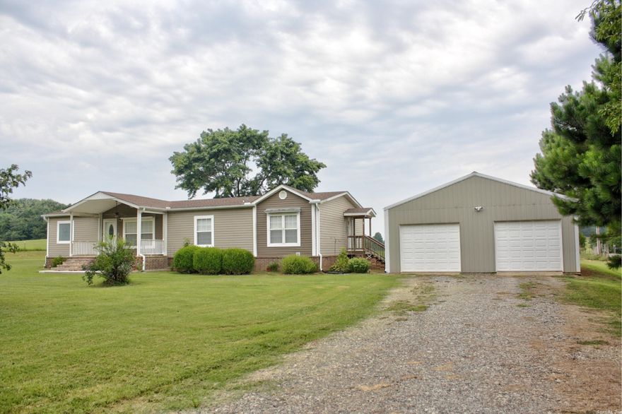 Yes, it’s a manufactured home, but it’s not your average or even above average double wide. This immaculate home is situated on a permanent foundation with a beautiful brick underpinning, sitting on 2 acres with a spacious 30' x 50' detached garage/shop boasting 10' sidewalls, insulation, and dual roll-up doors with openers. This versatile space is perfect for storing vehicles, tools, and pursuing various hobbies. Inside, the kitchen boasts a large breakfast bar and island, providing plenty of space for cooking or casual dining while the adjacent dining space has room for more of a sit down dining experience. The primary bedroom suite impresses with a step-in shower, a luxurious soaker tub, a double sink vanity, and a walk-in closet, offering a private retreat within the home. Step outside and enjoy the tranquility from either the covered back porch or the easterly facing front porch, perfect for hosting gatherings or simply relaxing after a long day.  Sorry, there’s no garden this year but the perfect spot awaits your green thumb in the spring.