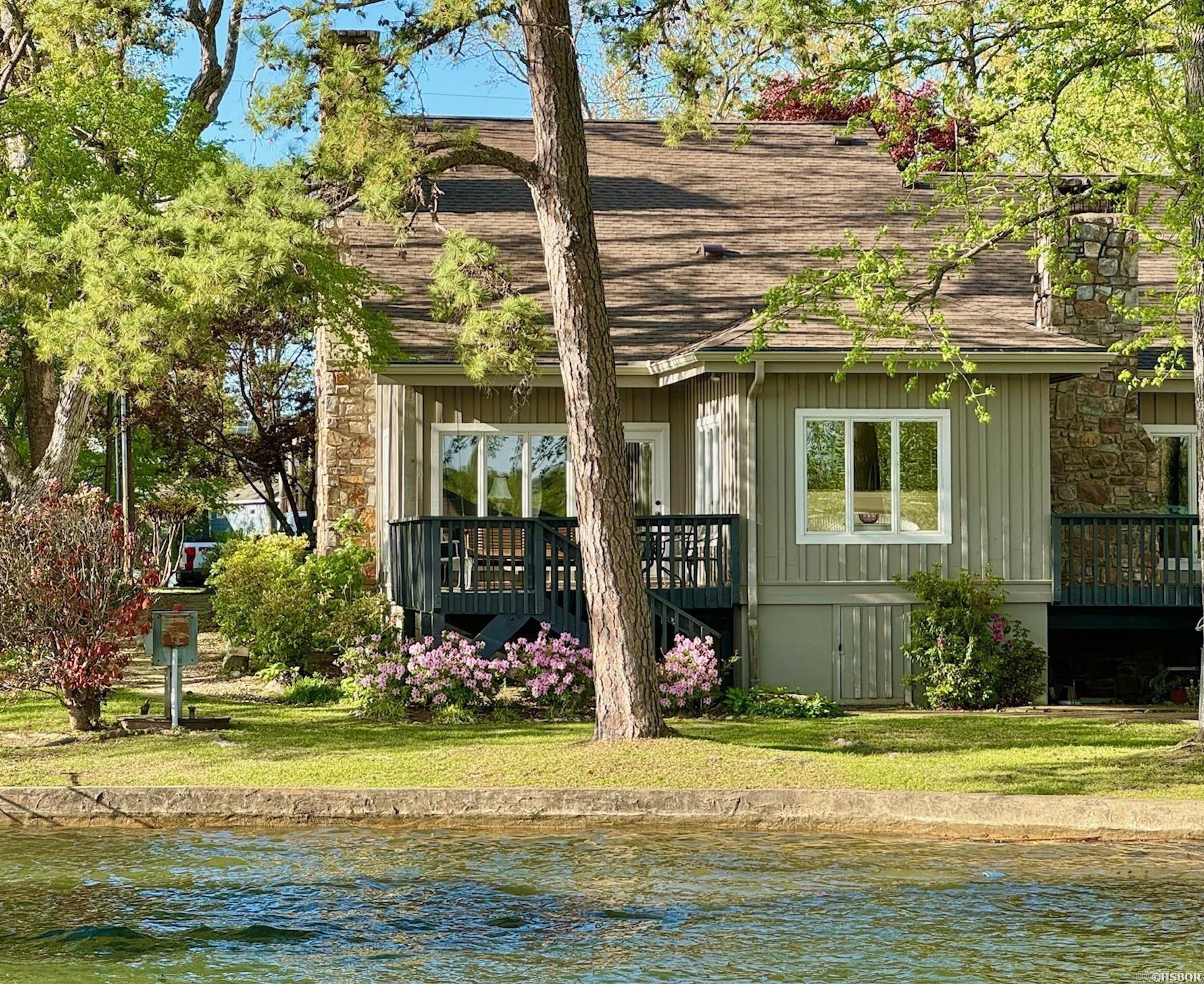 One-of-a-kind townhouse on Lake Hamilton! This 3 bedroom, 2.5 bath townhouse comes with TWO covered boat slips and is the largest of the three units in the complex, giving it a true "lake home" feel. Features are numerous and include a new roof, vaulted ceilings, massive stone fireplace, remodeled kitchen and bathrooms, huge walk-in shower and closet in the master bedroom, wood floors and stunning views of Lake Hamilton from the back deck. The common area includes a beautiful lakefront peninsula with covered gazebo area - the perfect place for relaxing by the lake. The location off Tanglewood Road (Hwy. 7 South area) is highly sought after - surrounded by million dollar lake homes. Don't miss your chance on this one!