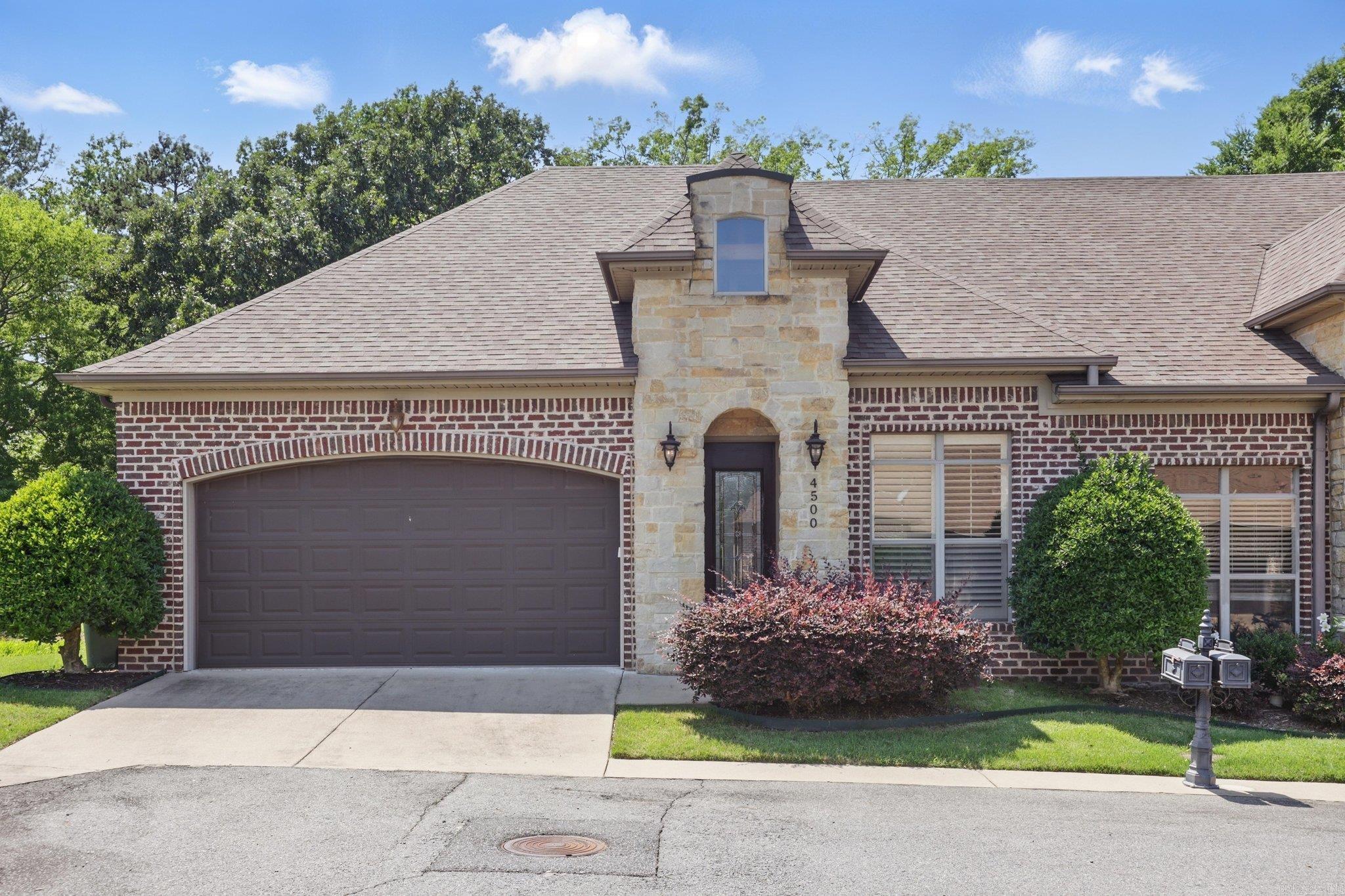 Tucked in a quiet cul-de-sac, this charming all-brick garden home offers tall ceilings, wood floors, and elegant molding throughout. The open layout highlights a spacious kitchen with custom cabinets, center island, pantry, and stainless appliances. Enjoy natural light and a cozy gas log fireplace in the living area. The main-level primary suite features a walk-in closet and en-suite bath. Upstairs you'll find two guest bedrooms, a full bath, and floored attic storage. New roof 2022/2023 and new carpet 2023. Washer, dryer, and fridge can convey with acceptable offer. Covered back porch overlooks a peaceful creek and fully-fenced yard. Lawn and sprinkler care handled by the POA.