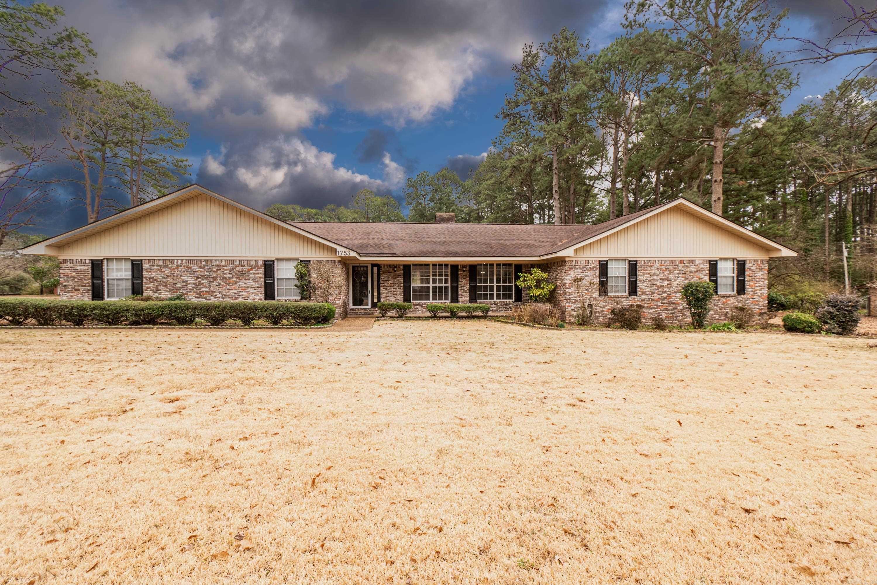 Discover the charm and comfort of this large 3-bedroom, 2.5-bathroom brick home situated in a prestigious neighborhood. This residence offers an exceptional blend of style, space, and convenience, making it the perfect place for families and entertainment. Enjoy the versatility of two separate living spaces, floor to ceiling brick fireplace, spacious bedrooms, a convenient half bath for guests located off the large laundry room, ample storage space throughout, attached two car garage, covered patio, fenced in backyard.... and yes! A 28x20 shop with roll up door with additional storage on back and a 16x30 and 12x20 carport, sprinkler system, and generac! This home is more than just a place to live; it's a place to thrive! Lot size and taxes taken from courthouse records