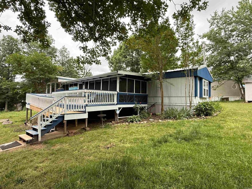 Just minutes from Norfork Lake, this well-maintained mobile home offers 2 bedrooms, 2 baths, and a versatile bonus room. Enjoy relaxing outdoor spaces with a large front, screened-in porch, front deck, and covered back deck. The large garage includes a built-in tornado shelter for added peace of mind. Recent updates include newer heating and air systems, making this property both comfortable and practical.