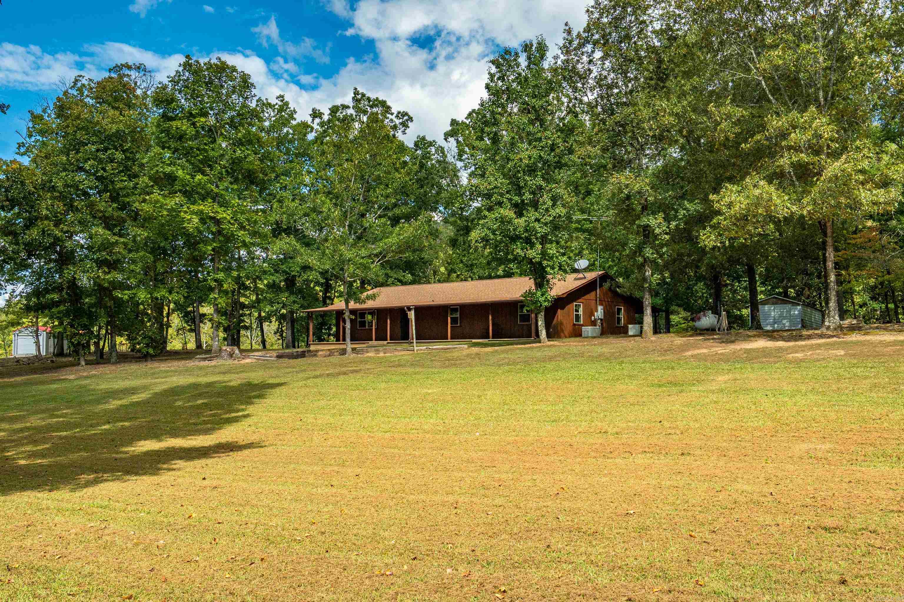 Charming Rustic Ranch with Mountain Views located in Lakeside School District! Welcome home to this inviting 3-bedroom, 2-bathroom country retreat nestled on 3.32+/- acres just minutes from Lake Hamilton. With beautiful views of Jack Mountain and an abundance of deer and wildlife, this property perfectly blends rustic charm and natural beauty. Step inside to find spacious living areas highlighted by warm knotty pine walls and timeless country character. Enjoy the outdoors from the large front and back porches, or host the ultimate cookout under the metal pavilion, complete with plenty of room for entertaining. A 30x54 metal utility building with electricity provides excellent space for storage, hobbies, or a workshop, and there’s an additional 10x18 metal storage building for even more convenience. Recent updates include new windows (2025), exterior paint (2025), a roof only 2 years old, and a septic system cleaned in 2024—all adding peace of mind for the next owners. Includes generator for added convenience. With its scenic views and thoughtful updates, this property offers the perfect blend of comfort and countryside living. SF via Tax Records-please feel free to measure.