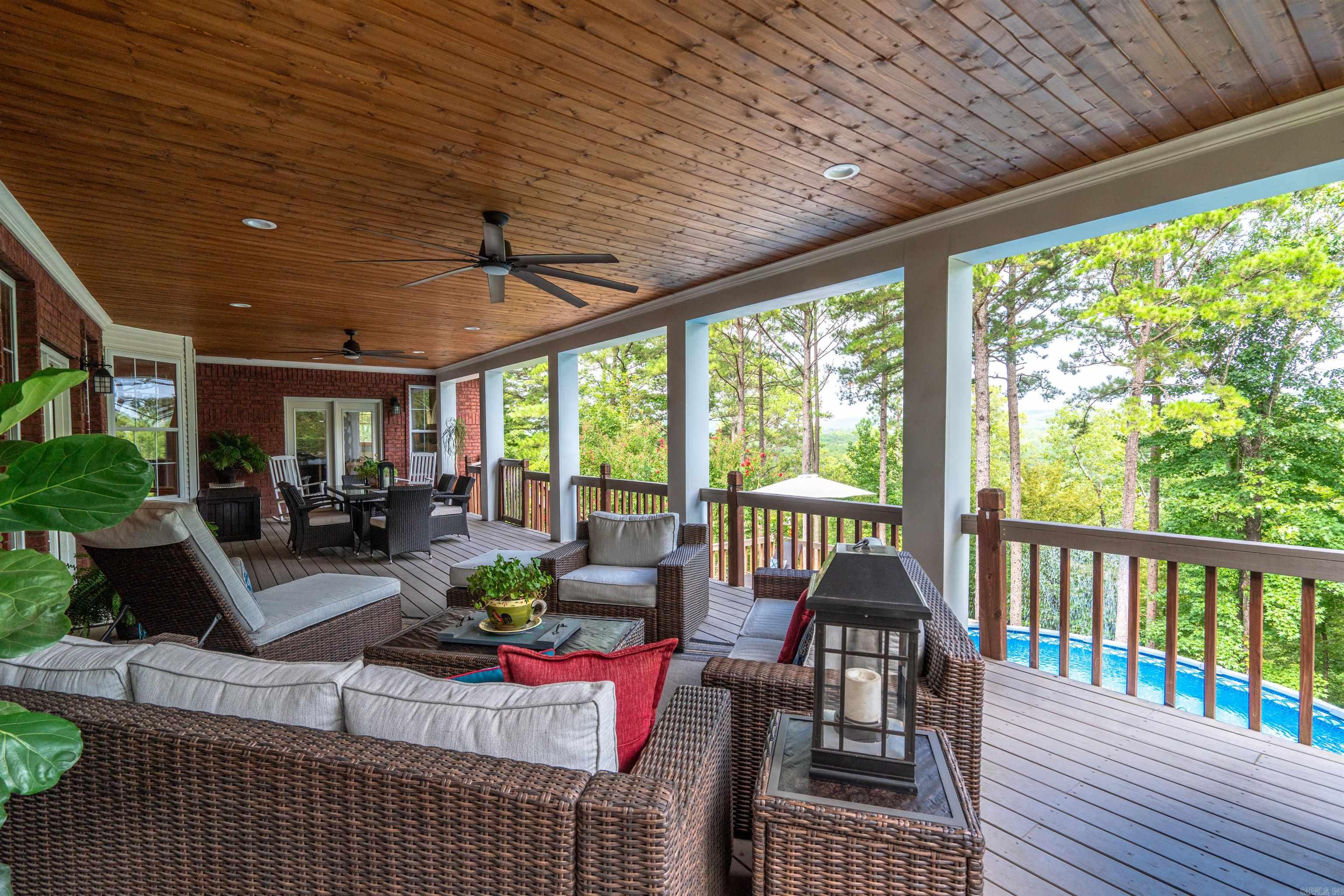 Your bit of heaven as you pass thru the private iron gated entry, up a gentle winding road to this ridge top custom brick 5 bd, 4 bath home sitting on on a lush 6 ac. forest parcel with views of the mountains & winter views of the Ouachita River below! Just slightly "off the grid" for that peaceful life. Ideal design for family, entertaining or even generational living. Spectacular 16x45 wood ceiling covered deck to accommodate grilling, dining & lounging for family & friends - & overlooks lower sunbathing deck surrounding an above ground saltwater pool. Vaulted ceiling living rm flows seamlessly from outdoor living to the kitchen & dining inside. Sequestered primary suite has private access to outdoor living & pool & has an en suite spa-like bathroom with a vessel tub & walk-in shower. 3 other spacious bedrooms & 2 baths on main floor. Downstairs is second living area w/wet bar, counter refrig, office nook, bedroom & bath w/walk-inshower...perfect for visiting family or mother-in-law. Upstairs rm for homeschool/crafts. 40x30 barn w/12 ft.overhead door, 30/30 attached lean-to on slab, firepit & fenced area for pets. Geothermal HVAC, roof (2019) & 2 generators. Add't acreage avail.