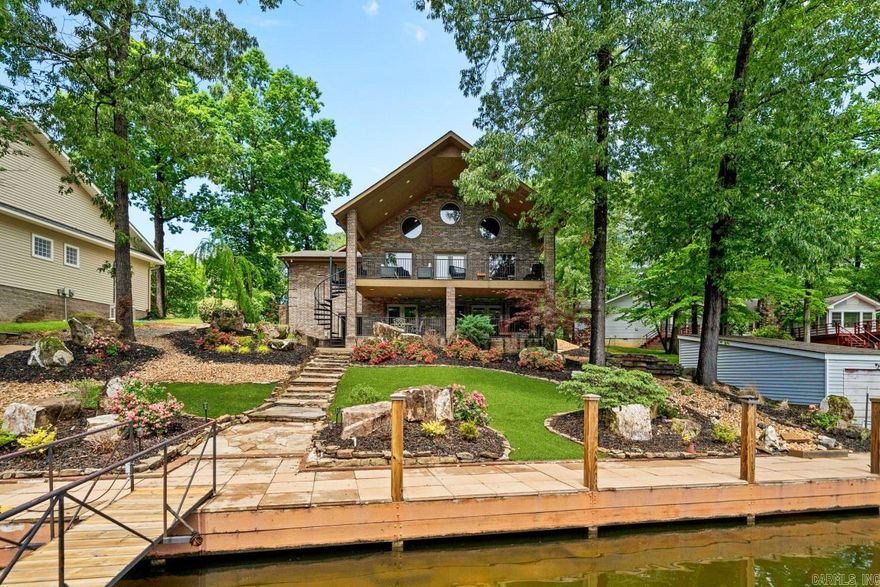 Masterpiece of Lakefront Living: This exquisite 5-bedroom, 4-bath residence has been meticulously transformed to perfection. Step inside and be captivated by the en-suite bedrooms, each a private oasis. The heart of the home—a chef’s dream kitchen—features opulent granite countertops, double wall ovens, and a professional-grade gas range. Vaulted ceilings adorned with intricate crown molding create an airy, grand ambiance, while beautiful hardwood flooring flows seamlessly throughout. Entertain in style within the game room, where laughter echoes against the walls. The expansive layout spans 4648 square feet, and that’s just the beginning. Two partially finished areas promise an additional 1000 sq. ft. of customizable space—whether you desire more bedrooms, a playroom, storage, or your own personalized haven (man cave or she shed). Outside, a covered deck and patio beckon you to savor tranquil moments by the water. And then there’s the pièce de résistance: the private boat dock with lift and jet ski dock, all conveniently accessible via your own private boat ramp.  This property is truly one of a kind!"