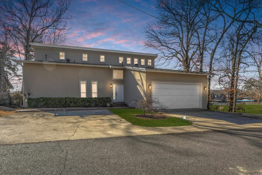 Experience waterfront luxury in this breathtaking two-story, 3,132 sq ft home nestled in Tanglewood. Enjoy sweeping Lake Hamilton views from the expansive wrap-around deck. The main level boasts a primary suite, guest bedroom, and hardwood floors. Upstairs, find a flex room and three bedrooms. Recent upgrades include new shingles, HVAC, windows, doors, and a $2,500 gutter allowance. With a double covered boat dock and community amenities, this is waterfront living at its finest. Schedule your showing today to make this your dream home!