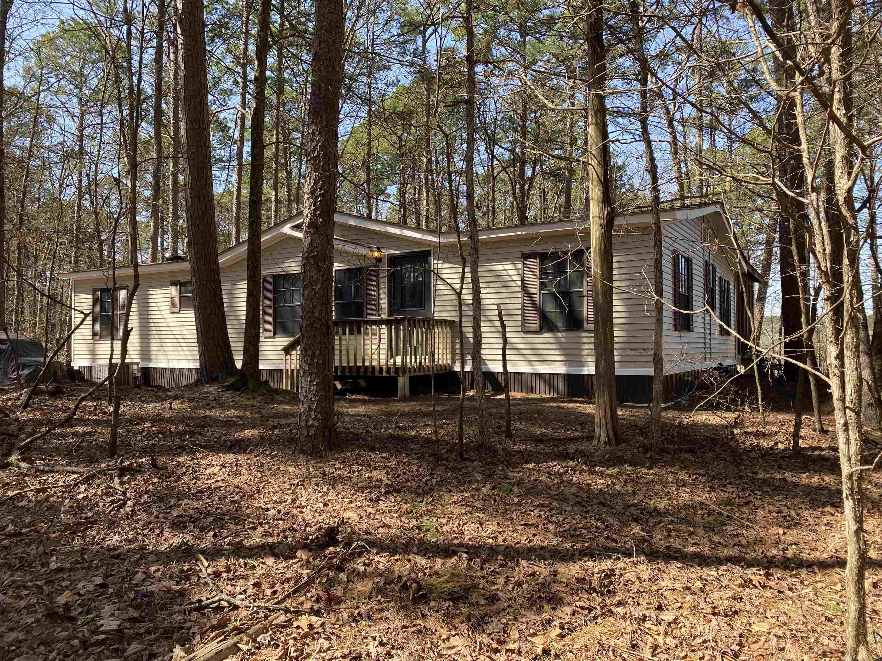 Check this home out! 3 bedrooms, 2 baths, approx. 1,456 sq ft, with a large screened in back deck for entertaining and trees for privacy. Vaulted ceiling in the nice sized living area with a wood burning fireplace and sliding doors to the screened in deck. Guest rooms each have double bunk beds so there is plenty of sleeping space for the kids AND their friends. This mobile home sits on .56 m/l acres and is located in Harbor South where you own the land it sits on! Call today for your private showing and start making your Lake Ouachita summer lake plans!