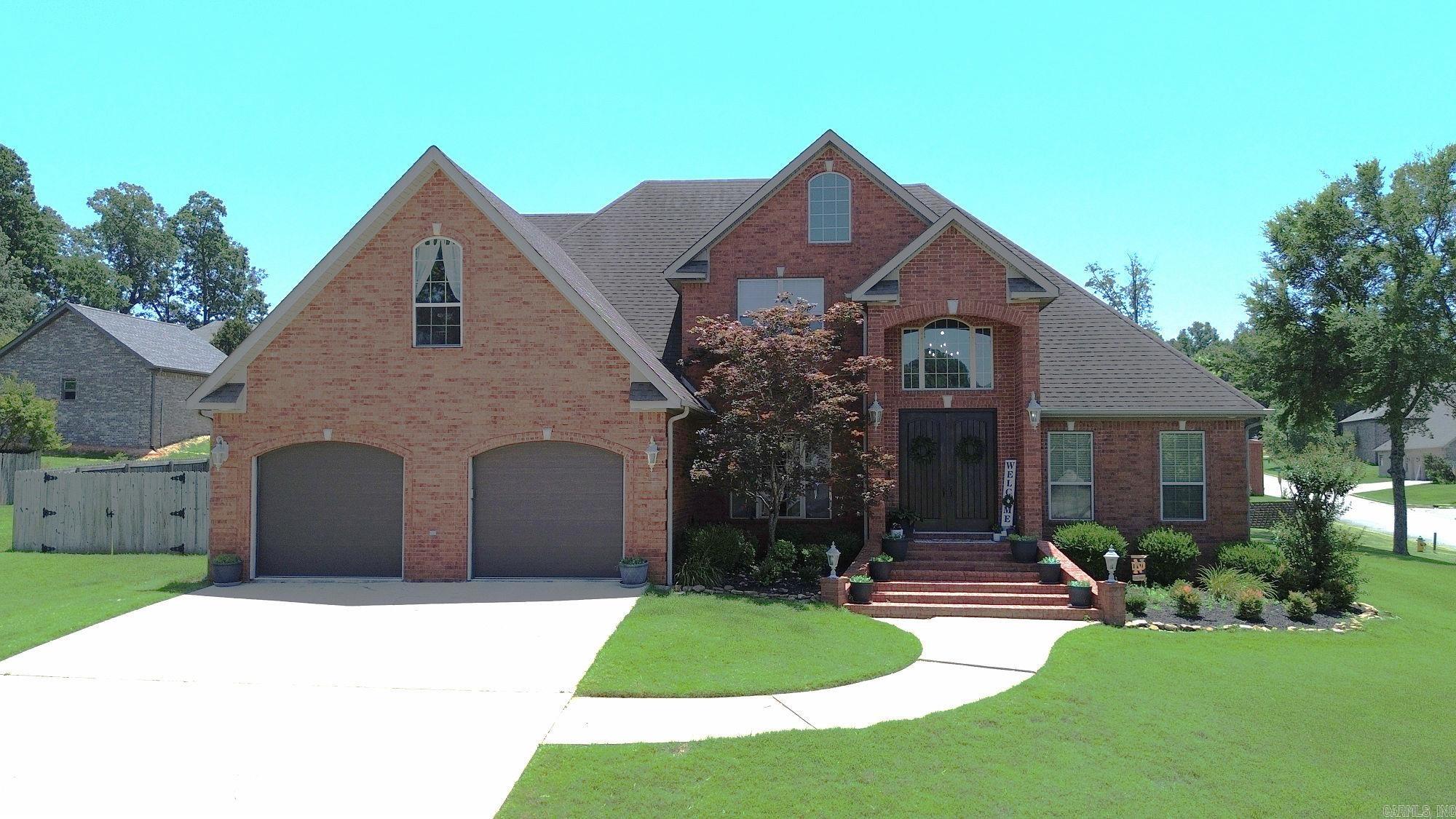 Spacious and elegant 5-bedroom, 3-bath home situated on a desirable corner lot in a quiet, walkable neighborhood close to the golf course! The main level features beautiful wood floors in the living and dining rooms, along with a gas log fireplace that adds warmth and charm to the generous living space. The kitchen offers granite countertops, a pantry, and a cozy breakfast nook. The main bedroom is a true retreat with a large walk-in closet, crown molding, and a luxurious en-suite bath featuring a whirlpool tub and separate shower. The additional main-floor bedroom offer convenient bathroom access. Upstairs, you'll find three oversized bedrooms, each with walk-in closets, and a full bath. Enjoy outdoor living on the covered patio complete with a gas log fireplace and mounted TV—perfect for entertaining year-round. This home offers space, style, and comfort in an unbeatable location!