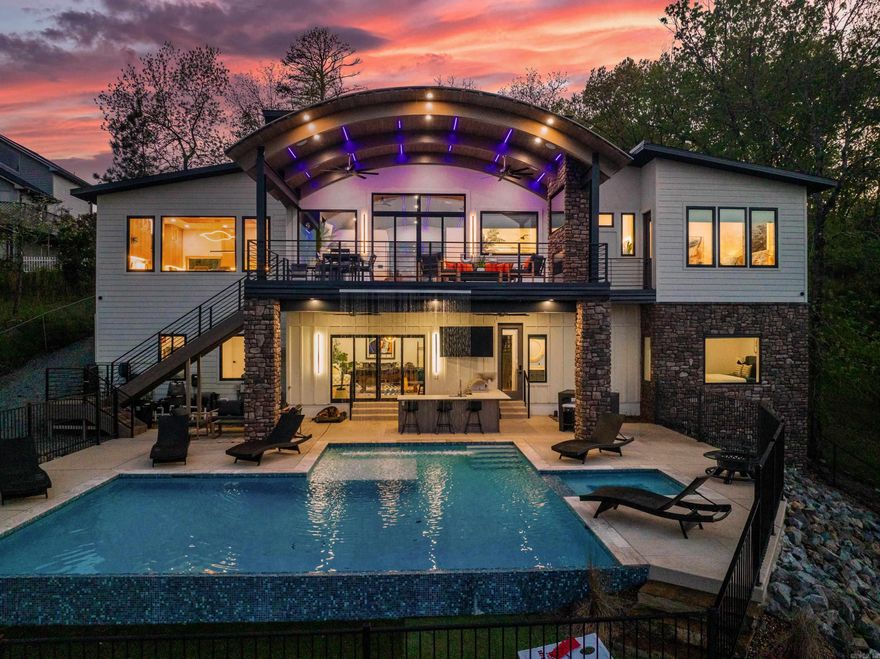 Featured on the cover of AY Magazine Home Issue, this stunning "smart home" combines luxurious appointments with high technology, impressing the most discerning buyer. Open the commanding front doors, & you're greeted with sweeping lake views & a custom barrel ceiling, a gorgeous display of the builder's craftsmanship. The incredible kitchen features upscale Dekton countertops, rift-sawn red oak cabinets, German steel faucets, & a Miele gourmet built-in coffee maker. The master suite offers a true spa experience with a curb-less shower, a free-standing soaker tub & Flourco color-changing mirrors. The chic outdoor oasis blurs the lines between indoors & out, with an in-deck waterfall that cascades from the top deck down to the heated pool & outdoor kitchen below. With the click of a button on your phone, you have energy-efficient climate & appliance control, video surveillance, electronic locks, intercom system, show-stopping lights & music of your choice. Turn on the hot tub & adjust the temperature before arriving home; or start your laundry after you leave for work. This home is a true work of art & is projected to generate $300k/annually as a nightly rental. Agents, see Remarks.