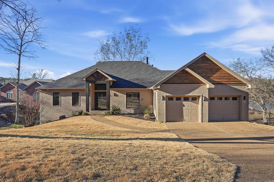 Beautifully updated lakefront home tucked away on a quiet cove on Lake Hamilton, with easy access to Mazarn Creek—perfect for fishing and relaxing lake days. Enter through a custom glass front door into a spacious open living area and kitchen, ideal for entertaining. Step outside to a generous two-level deck offering multiple seating areas and peaceful cove views. This home offers excellent space for family and guests with four bedrooms, including a primary suite on the main level and three additional bedrooms on the lower level. The lower level also features a second living area and its own deck, creating a comfortable retreat for guests or extended stays. Located in a gated community with many year-round residents, the property provides both privacy and security. Enjoy direct access to a two-slip covered boat dock with a new lift and two jet ski pads. Additional features include a full-house Kohler generator, a new roof installed in 2023, and an elevation certificate on file. The home is not located in a flood zone.