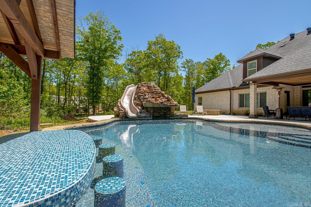 This rare secluded gated 6 estate subdivision.  Sits on a 1.79 acre lot with mature oak trees for privacy on the back porch with a fireplace.  This home has 4 possibly 5 bedrooms.  The bonus room has a full bath.  The kitchen has plenty of room for cooking and entertaining with granite countertops stainless steel appliances. With tile in all wet areas and wood in living.  This lot has room for your dream shop.   You have plenty of area to add your own circle drive right to the front door.  There is a new gunite pool with a grotto and a slide.  With this pool you have to have a swim up bar and cooking area.  This is a must see!!! Only 5 miles from I-30