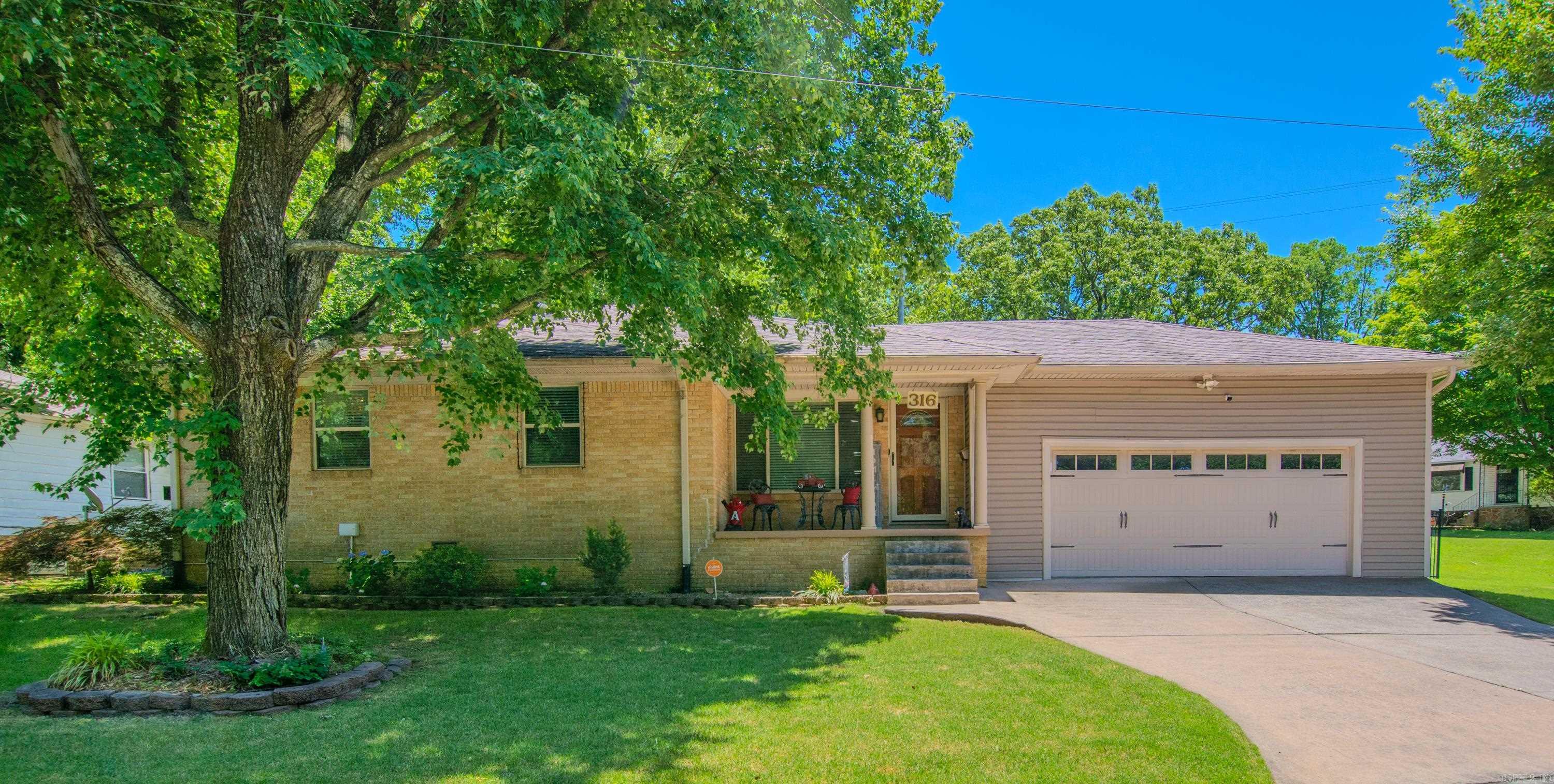 Welcome home to this charming property featuring a lovely covered front porch and beautiful mature shade trees. Enjoy the convenience of a two-car garage, a separate storage building, and a spacious fenced backyard with a large side yard—perfect for outdoor fun and entertaining. Inside, you'll find wood floors throughout the living room, dining area, and kitchen. The kitchen offers a breakfast bar, plenty of cabinet space, and is ideal for everyday living or hosting guests. The updated hall bathroom adds a modern touch, while the backyard boasts a patio, pergola, and a tiered layout that makes the most of the outdoor space. Don't miss this inviting home with both comfort and character!