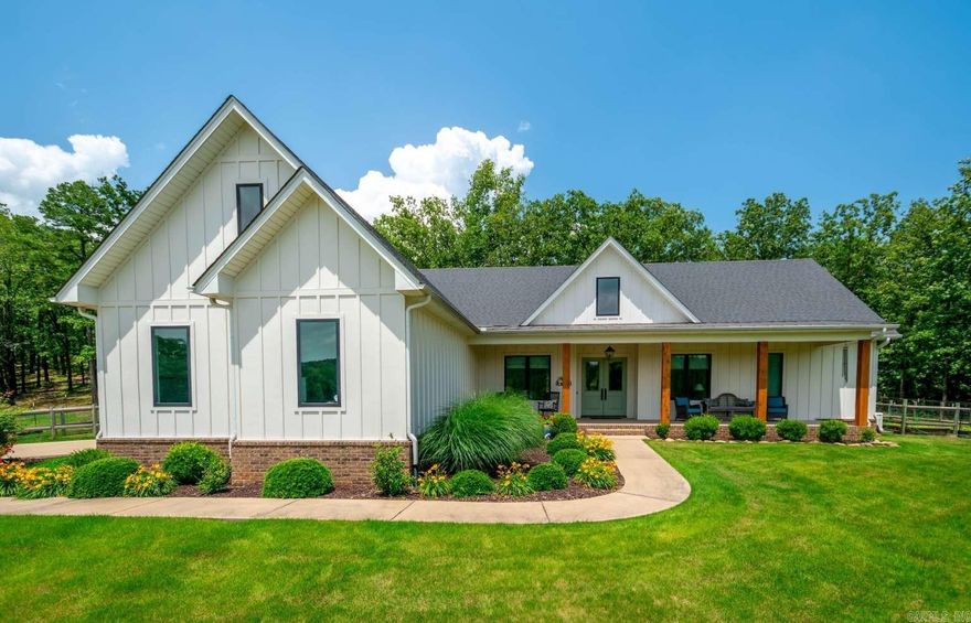 Unwind in this modern farmhouse with 4 bedrooms and 3 full baths, set on 20 acres just minutes from Conway and I40 in Mayflower. The home is enhanced with many custom upgrades, including spray foam insulation, Generac home generator, and safe room. It boasts two fireplaces with wireless remotes and large Andersen fibrex windows that offer breathtaking views. The interior showcases 10-foot ceilings, 8-foot doors, and wide baseboards and crown molding throughout. Additional features include shiplap and wainscoting, handcrafted barn doors, and a recirculating tankless water heater. The exterior is clad in “Hardie” board and batten siding, with fenced raised garden beds and zoysia grass. Enjoy the spacious screened porch with a fireplace, an outdoor deck, and a barn for extra convenience. The barn measures 30’X40’X12’ and comes with electricity, water, and two overhead doors. Furthermore, there is a second home building site near the barn, with utilities already available. With abundant deer and wildlife, the property is beautifully surrounded by mature oak trees. A home of such exceptional craftsmanship, tranquil views, and careful maintenance truly represents the pinnacle of quality!
