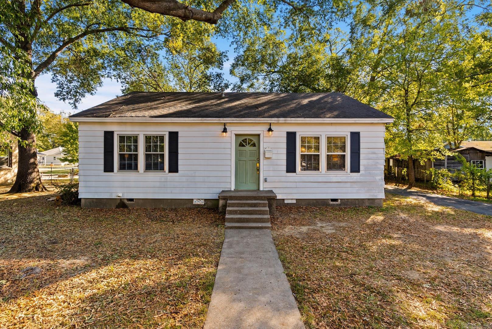 Make your way to Mitchell Street. This cozy little cottage tucked in quaint old town Conway seated on a large lot is now on the market and ready for new owners. Upon the entry you're welcome with handsome refinished original hardwoods in your living room. Off the living is your remodeled kitchen with ample cabinetry and farmhouse sink, plus a small bar that overlooks the living room. 3 bedrooms or 2 beds + office/laundry, and a recently remodeled bath. All the character of a cozy bungalow but with modern tasteful touches. At the backyard is a large patio and a deep, flat & fully fenced lot. Great for hosting friends and letting the dogs & kids play. Don't miss the detached garage that can store a sedan or be used as storage, a workshop, or with some TLC a man cave or she-shed. Just minutes from downtown Conway. Don't miss this home!