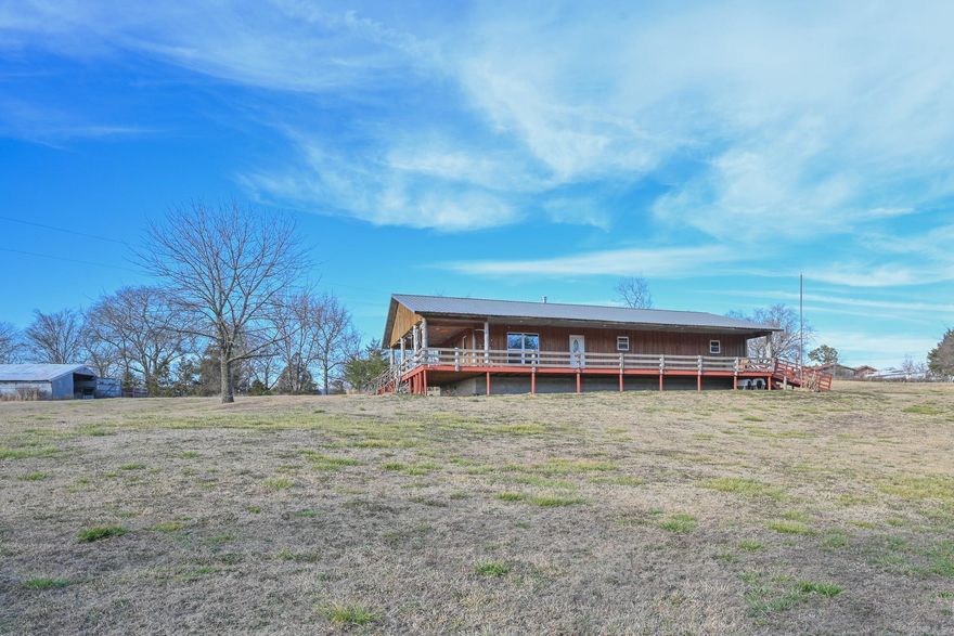 Looking for a beautiful country home with VIEWS and privacy? Take a look at this SPACIOUS 3 bedroom rustic country cabin on 10 picturesque acres with a seasonal creek! The home features a wraparound gated porch inviting you to relax and take in the peaceful surroundings. Inside, you’ll see an attractive open floor plan, vaulted ceilings and a wood burning stove complete with rock hearth! With spacious bedrooms, walk in closets, a custom rock shower, and jack & jill sinks in the primary bathroom, this home has been thoughtfully designed with attention to functionality and rustic charm. Throughout the home there are several cedar walls and impressive live-edge trim throughout. The large kitchen features a custom wood backsplash and rich wood countertops. The very spacious laundry room and pantry include a half bath, water heater closet, and convenient access to the large crawl space below. A 40x60 metal open shop offers endless possibilities. Across the creek, a gravel pad is already equipped with septic, water, and electric. Outdoor enthusiasts will appreciate the property’s close proximity to the Ouachita National Forest, ATV trails, and The Mountain Bike Trails!