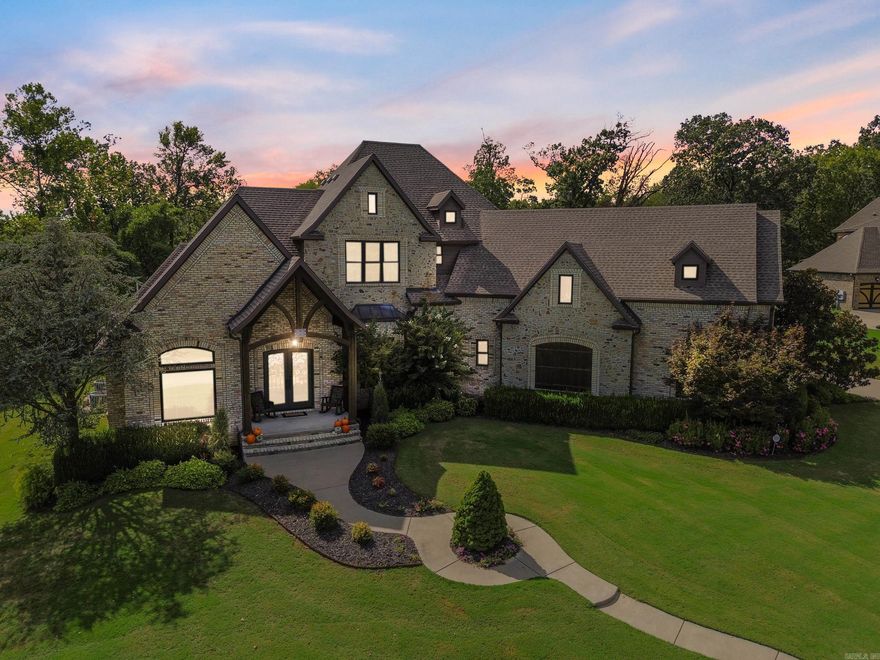 One of Bentonville’s most sought-after addresses. This custom estate strikes the perfect balance between privacy and convenience—nestled on nearly an acre of level, tree-lined land, yet just minutes from downtown Bentonville, Pinnacle Hills, and XNA. Step inside and you’ll be greeted by vaulted, beamed ceilings and an open, light-filled layout that feels both grand and inviting. Handcrafted cabinetry, designer tile, and premium finishes carry throughout the home, while fresh 2025 paint and newly updated landscaping give every space a crisp, modern feel. Each bedroom features its own ensuite bath for ultimate comfort and privacy. A dedicated office, movie theater, game room, and two spacious living rooms provide flexibility for work, play, and relaxation. Out back, the covered patio overlooks your nearly one-acre flat backyard—perfectly suited for a future pool—framed by a natural tree line that offers peace and seclusion. And when the weather turns, rest easy knowing you have a built-in F4-rated storm shelter, offering safety without compromising style. This is Bentonville living at its finest—thoughtfully designed, beautifully finished, and ready to welcome you home!