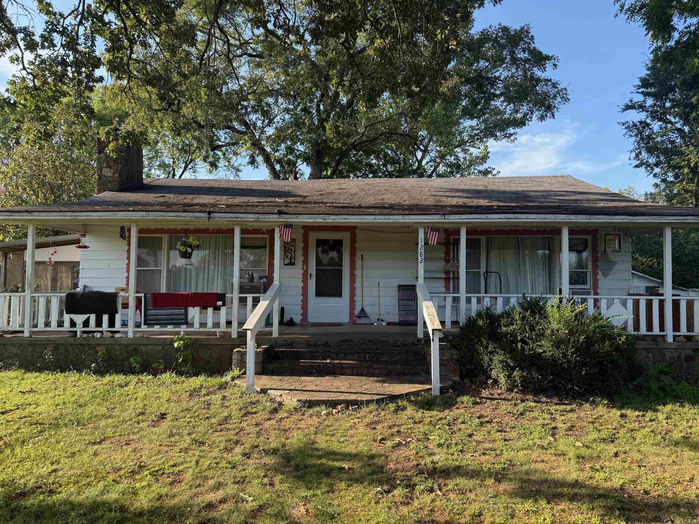 Charming Country Home with Spacious Yard, Screened Side Porch, Pasture & Detached Garage. Nice 3 bedroom, 2 bathroom home featuring a large front porch overlooking a spacious recently fenced yard. Property boasts beautiful mature trees, includes a 1 car detached garage, paved road frontage, and a circle driveway for easy access. Larger bathroom and flooring in smallest bedroom updated this year! Enjoy the peaceful setting with a small pasture beside the house - perfect for gardening, hobby farming, or outdoor enjoyment. Fireplace in the living area (not tested by current owners). Located just minutes from the Mountain Fork River and near scenic riding trails. Great opportunity for country living with modern convenience.