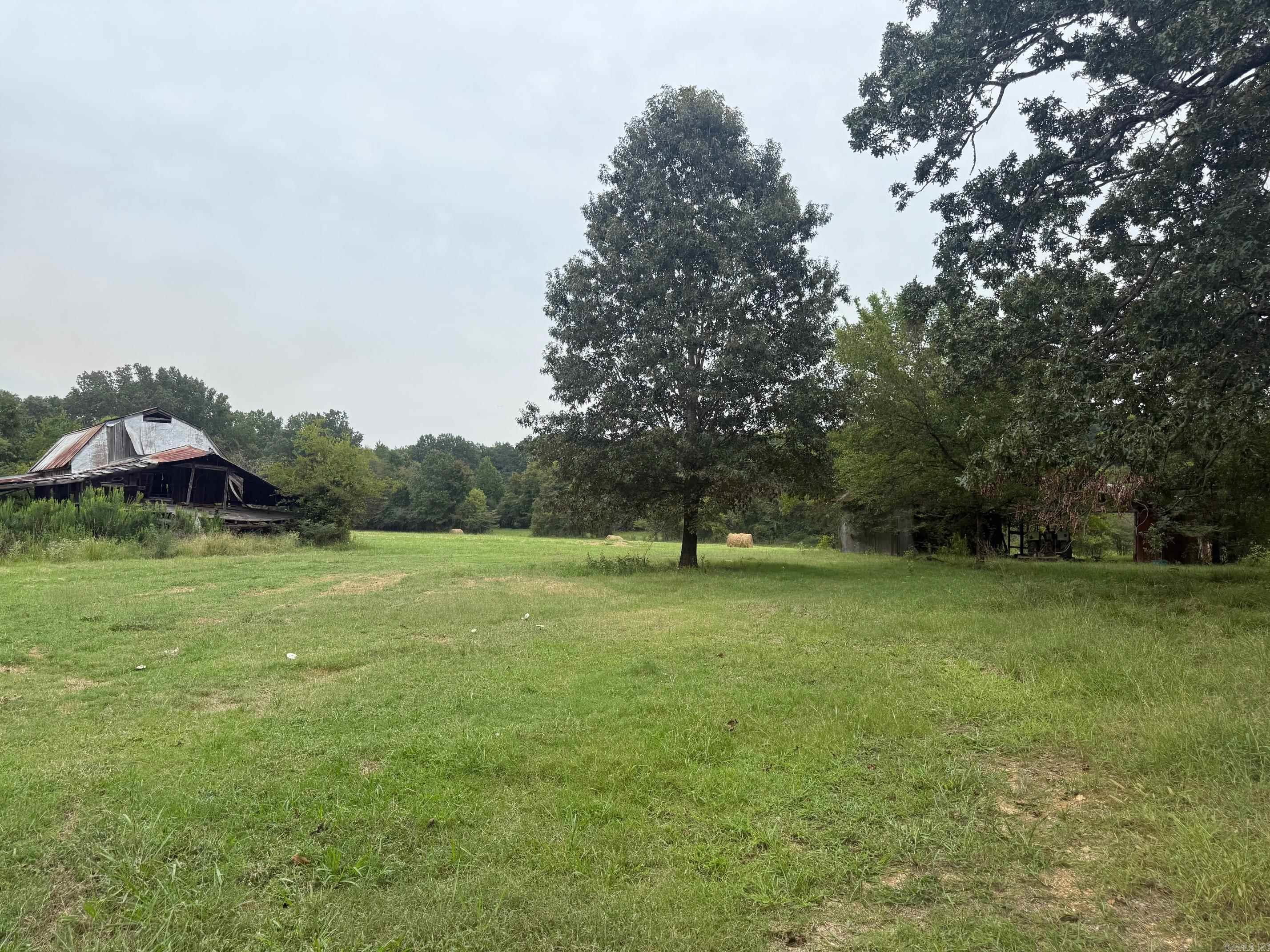 Welcome hunters and homesteaders! This is a beautiful 51.93 acres of paradise. Large trees and open fields make it the perfect country setting. The old house resides at the entrance where utilites have been in the past, and city water is now available at the road. Pass through the gate to the old barn and then the view opens up into beautiful pasture and woods. A large pond is also on the property and deer are known to frequent the property year around. There are no property restrictions. It is a one-of-a-kind find! Also could be easily sub-divided for investors. Call for a showing today!