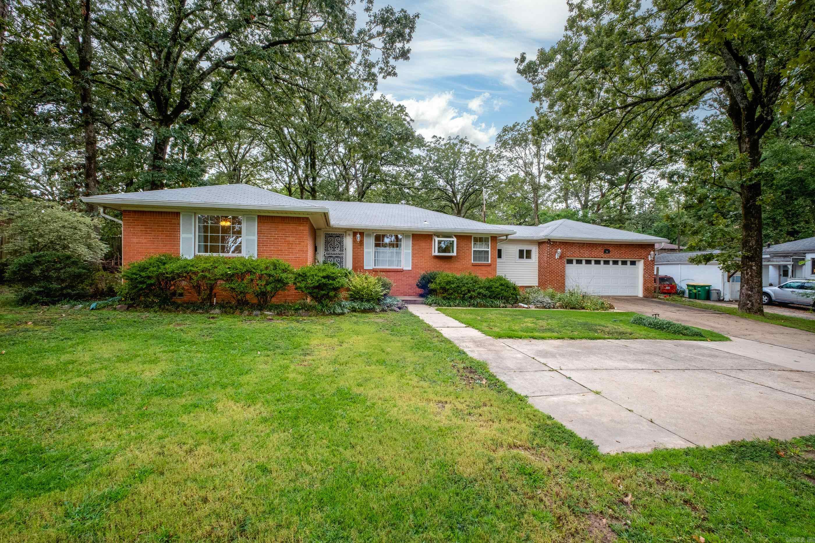 Your search ends here! This move-in-ready, one-level brick home is a rare find. Inside, you'll love the beautiful hardwood floors and floor to ceiling windows overlooking the gorgeous backyard. With a renovated kitchen, new bathroom in the primary bedroom, fresh paint throughout, key electrical upgrades, and a high-efficiency HVAC system in 2023, the hard work has been done for you. The real magic begins outdoors with the incredible oversized double lot. The expansive, fenced yard is an entertainer's dream, featuring a generous patio for gatherings and ample green space for recreation. A true gardener's paradise awaits, with an edible landscape of apple trees, berry bushes, and muscadine vines, surrounded by the breathtaking beauty of heirloom roses and irises. There are endless possibilies with a 25x20 workshop/studio with 220amp electric service and a 9-foot roll-up door. An oversized heavy-duty double gate off the alley offers easy access to the shop and the backyard. This amazing feature, combined with the two-car garage, and convenient location makes this property one of the most versatile and desirable homes on the market today!