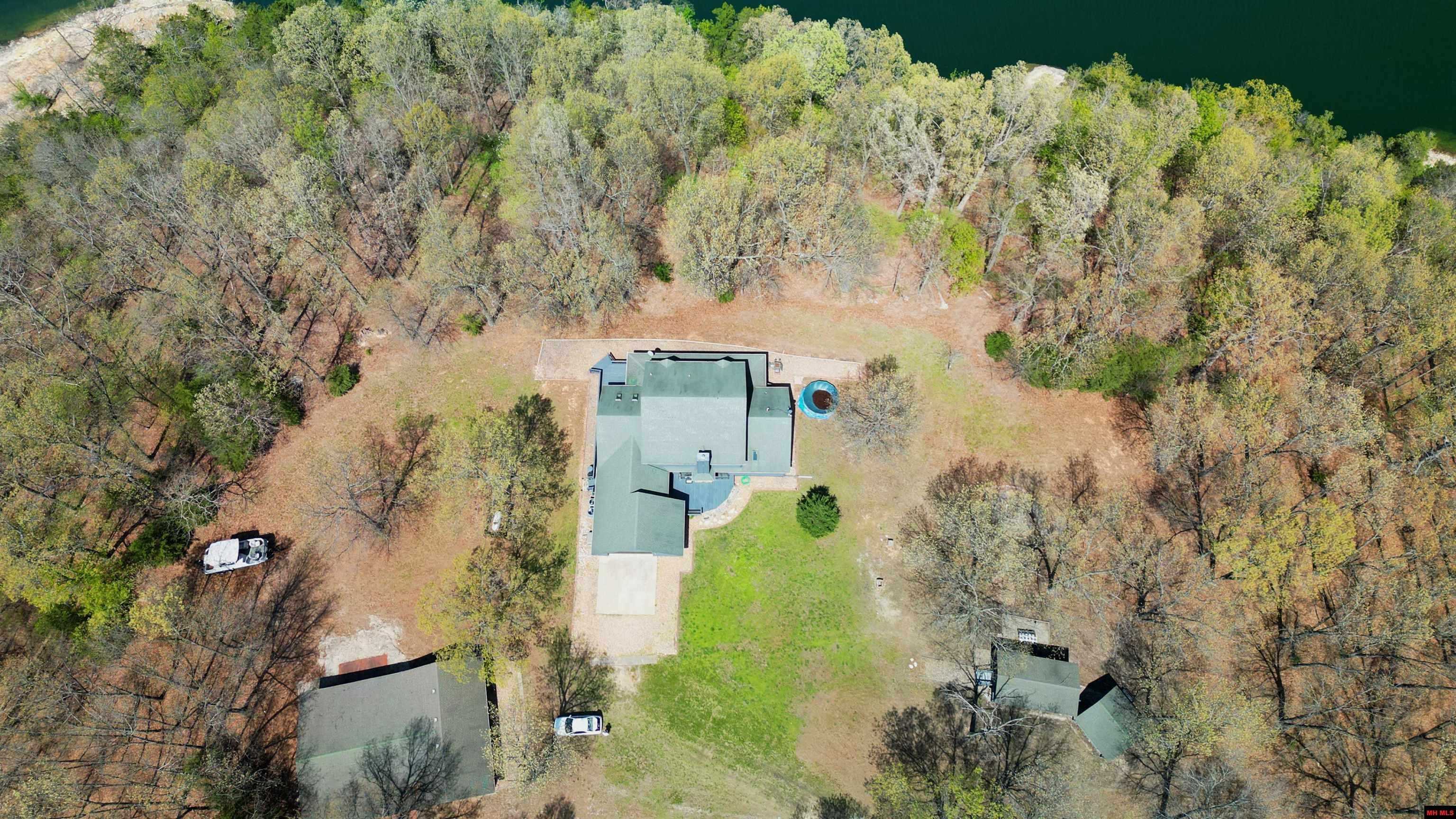 Looking for your own slice of heaven? Welcome to this stunning lakeside estate on 3 acres m/l with end-of-the-road privacy and incredible access to Bull Shoals Lake! This one-of-a-kind 4-bedroom, 31/2-bath beauty offers over 5,000 sq ft of comfortable, spacious living—perfect for hosting, relaxing, or just soaking in the good life. Step inside and head down to the basement, where you'll find a custom-built bar and a huge open area—ideal for a game room, man cave, or the ultimate kids' hangout. Whether it’s movie nights, ping pong tournaments, or weekend parties, this space is designed for fun and entertaining on a grand scale. Step outside and fall in love with the outdoor kitchen, gazebo, covered front porch, and breezeway connecting to a massive 32’ x 40’ covered patio/carport—perfect for lakeside gatherings, summer cookouts, or simply unwinding under the stars. Plus, there’s a 24’ x 40’ detached garage with room for your boat, workshop, or weekend toys.
