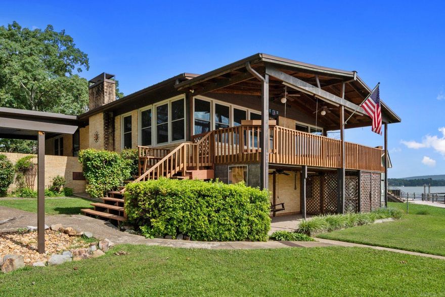 This is your opportunity to own a main-channel gem that has been cherished by its owners for over 30 years! Enjoy sweeping water + mountain views from a secluded cul-de-sac off Majestic Lodge Road, where trees canopy the street and deer roam. Be part of the action with ample room to store boats and water toys in the 2-stall covered dock, detached garage, and multiple carports. For days at home, enjoy watching water activities from your covered porch or wall-to-wall windows lining the living room and kitchen. This property has been very well-cared for. The big-ticket items have been taken care of for you, including replacement windows, a metal roof, new HVAC system, gutters, and electrical updates. There is a level, grassy lawn with a fairytale gazebo and space to add a pool if desired. Investors, this property is located outside the city limits and is not a restricted subdivision. With 5 bedrooms + a fun entertainment space with a “speakeasy” vibe, there are so many possibilities to enjoy!