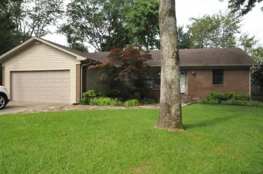 If you enjoy the outdoors, this house is for you.  HUGE lot with a beautiful koi pond with waterfall.  Out building with shed is fenced separately from rest of backyard.  Nice fiberglass storm shelter.  Lots of shade trees.  Inside there are tile and laminate floors throughout, and a  gas log fireplace. One bedroom had closet removed by former owner but can easily be put back. Walk in pantry.  Stone patio.