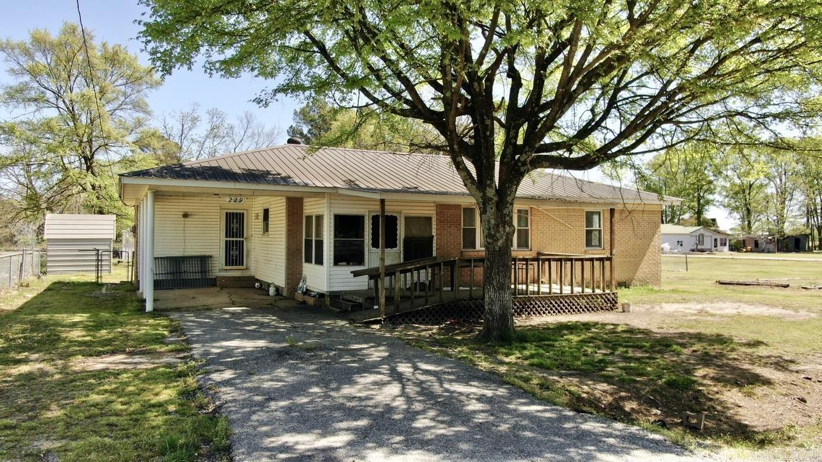 Say hello to 229 E Elm! This adorable brick home in Alicia, AR is the perfect spot for your new home, duck lodge, or an investment property! Located on over 5 lots, there's ample room for a large yard or the potential to build more homes. The property features a durable metal roof and a screened-in front porch, perfect for enjoying the outdoors without the bugs. The fully fenced backyard is ideal for pets or outdoor activities. Two storage buildings offer extra space for tools, equipment, or hobby projects. Situated on a corner lot, the home offers easy access and a spacious feel. Whether you're looking for a peaceful retreat, a family home, or an investment opportunity, this property has it all. Don’t miss out on this versatile gem!