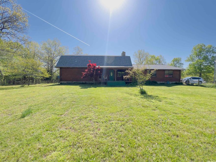Looking for a secluded home with paved county road frontage? Nestled on the outskirts of town, this cedar log home sits on 10+/- acres in Izard County. This property offers the perfect blend of rustic charm and modern convenience, all just 15 minutes from the town of Melbourne.   With 2,600 sqft of living space, this 3 bed, 2.5 bath move-in ready home features a vaulted ceiling in the living room & a cozy wood-burning fireplace.   Two bedrooms, along with one full bath and one-half bath are on the main level. Upstairs you will find a bonus den area, as well as the master bedroom and a full bathroom.   The home is complete with laminate wood flooring and hardwood flooring. The home has central heat and air with a backup generator that will stay with the property and backup propane heat. Features of this home are the two-car garage and the Malarkey shingled-roof that was installed last year. It comes with a 40-year warranty and is made from recycled rubber. A generator is included.  This property has an apple tree, a creek that runs year long and two weathered ponds. It also includes a new barn, corral, and feed shed measuring 19ft x 20ft.   All of this is listed for only $339,900.