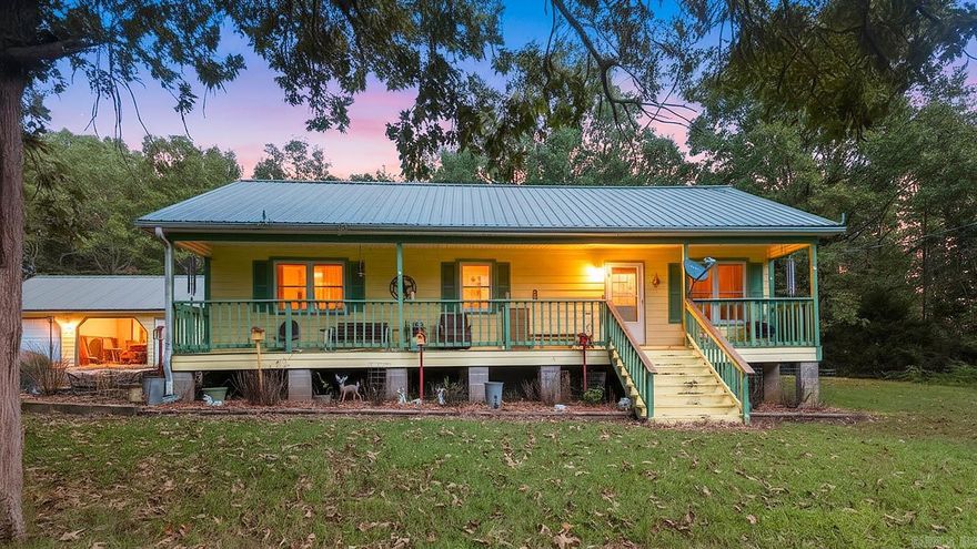 Set on a pretty mix of woods and open ground, this 3 bed, 1 bath, 1,250 sq ft home is a ready-made retreat for outdoor living. Hunt on your own land with a private pond, hunting cabin, tree stand, tripod stand, and feeder already in place. Game cameras have shown whitetail deer and black bear, making this a true sportsman’s spot.  The single-level home includes a newer metal roof, easy crawl space access, and covered porches front and back. The rear porch is built for gatherings with two seating areas, a bar, grilling space, and a wheelchair-accessible ramp.  Outbuildings add real utility: a spacious shop for two vehicles and a golf cart, a woodworking area, a heated and cooled craft room, and a rabbit house. The front yard is open and inviting with a large pond, tire swing, and room to play. In back, a storage building, well house, and trails lead directly to hunting stands.   The property is fully fenced for privacy and security, separating you from neighboring land. Whether you want country charm, a hunting getaway, or space for hobbies and gatherings, this Camp, AR property checks the boxes.