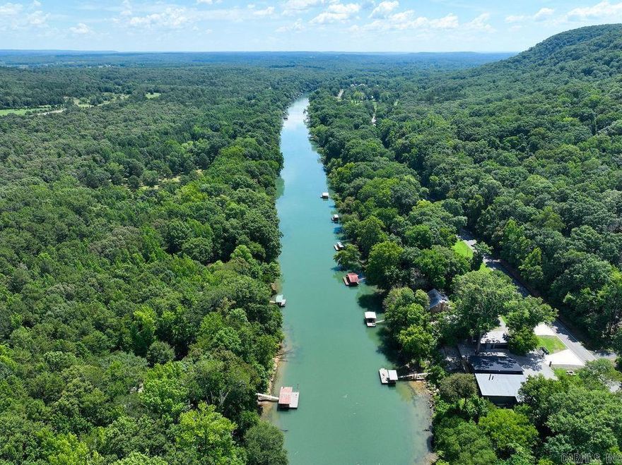 This beautiful home on the Little Red River offers serenity with over 2 wooded acres of privacy at the end of Wildflower Lane. It features 2 full "master " suites and 2 guest rooms, spacious decks and patios for outdoor enjoyment, a boat dock with electric boat lift located on one of the best streches of the River to fish, all with views of Libbby Bluff across the River. The open living/dining has a fireplace to warm you while you enjoy the views.The 2 car attached garage has permanent stairs to the attic and there is a large detached shop/garage for storing boats and lake and river toys. With over 200 feet of river frontage, you could possibly divide a 100 ft. lot to sell or if you would like to have more land there is an additional 8.1 acres available. Enjoy evenings around the firepit overlooking the river and to compliment the world class trout fishing the private subdivision lake is there for warm water fishing for bass, bream,etc. Fiber Optic internet service has been installed.Call today for your private showing.