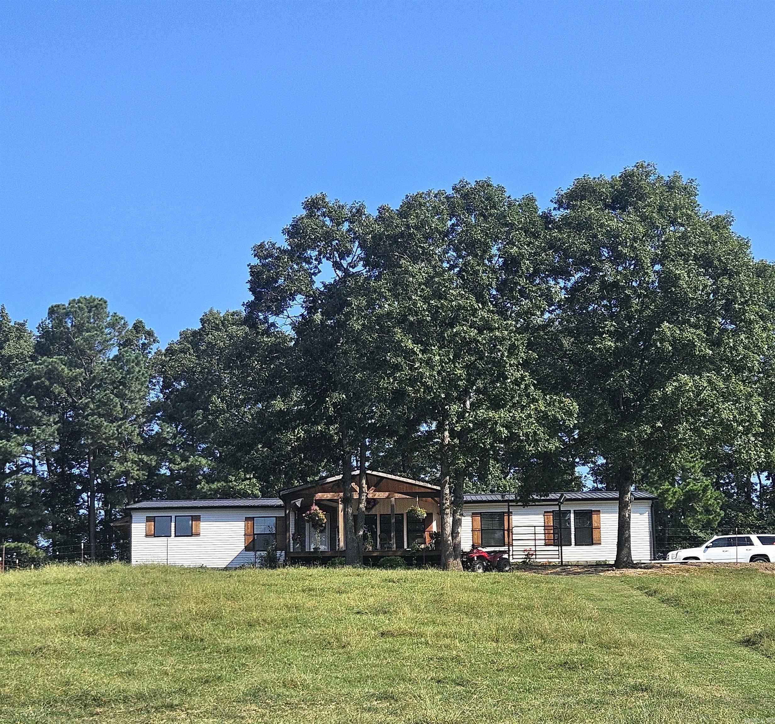 46.15-acre farm, featuring a 3BR/2BA custom home with 2280sq.ft, plus a 20x30 cabin, 50x40 insulated barn, concrete floors, electrical, with sheds on both sides of the barn. The farm includes cross-fencing, corrals, chicken coop, dog kennel, four ponds, three pastures, and a year-round creek. These features allow for rotational grazing and can accommodate 45-50 cattle. The home offers a spacious living room with fireplace, office, gourmet kitchen, primary suite with soaking tub, tile shower, and walk-in closet. Covered front and back porches provide views of rolling pastureland. Property is close to Shady Lake, Cossatot River, Caddo River and Lake Greeson all excellent for camping, hunting, and fishing. This exceptional farm offers everything you need for a productive homestead, working cattle farm, or private country retreat.
