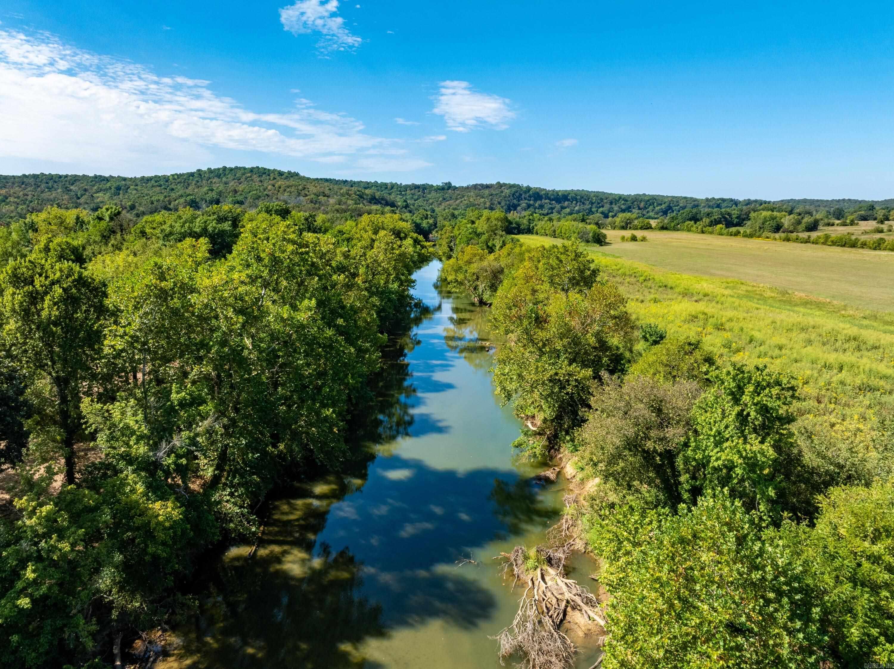 Strawberry Riverfront – rare find in Sharp County, AR. About 3,300± ft (~0.62 mi) of Strawberry River frontage just outside Poughkeepsie. A new, graveled access road allows passenger-car travel across the tract. Beautiful mix of hayfields, pasture, and timber with multiple homesites and long river views. Cabin on site for immediate use while you plan your build. Utility easement in place; no utilities installed (great off-grid potential—solar + private well). Former boat-ramp area for easy put-in/take-out. Excellent deer and turkey presence. Ideal for a river cabin, forever home, hobby farm, or hunting retreat. Appointment required. Equal Housing Opportunity.