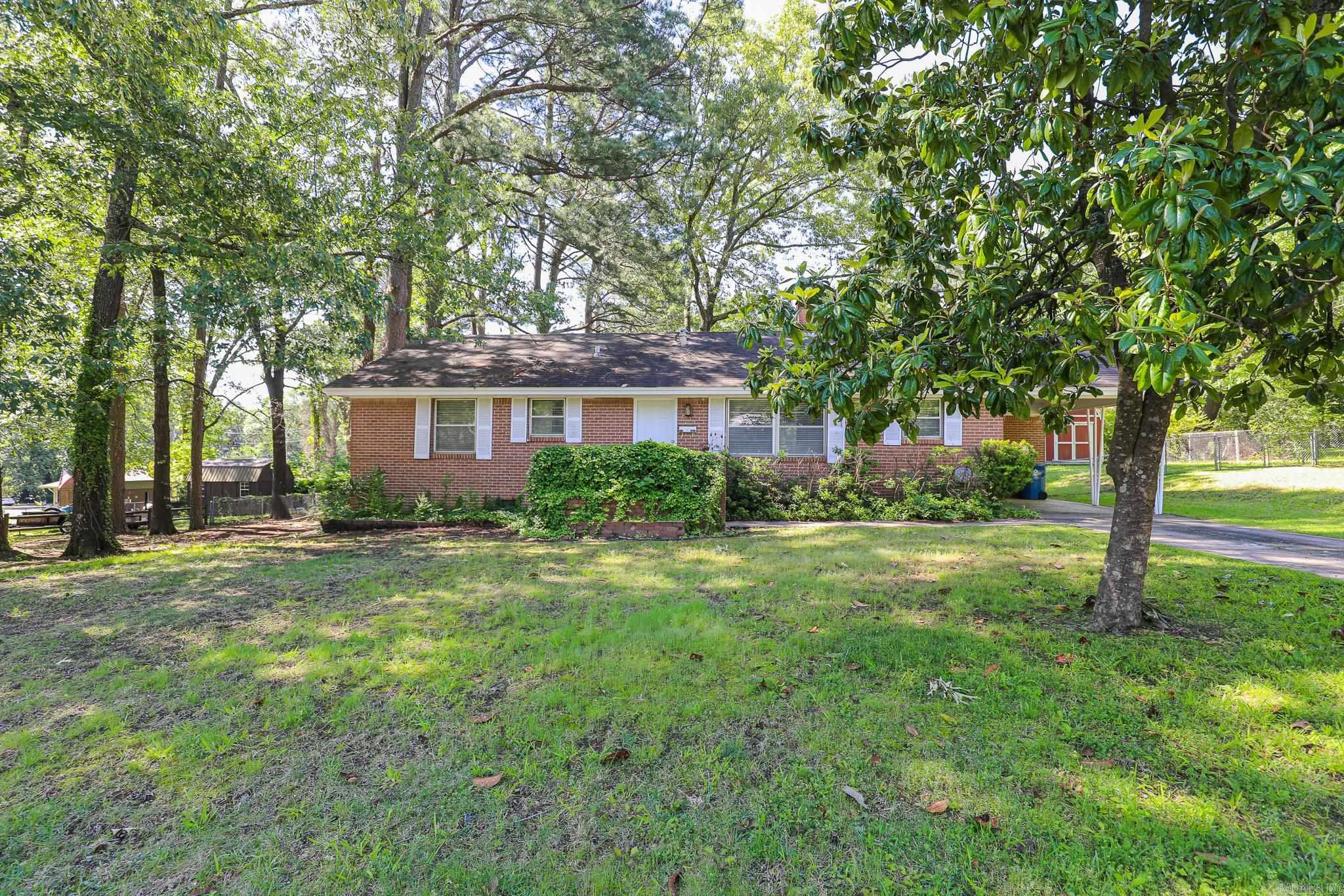 Brick Home on 2.5 city lots. 3 bedroom 2 bath. Living area w/wbfp. Separate Dining area. Ceramic tile floors in wet areas and beautiful light wood floors in all other rooms. Primary bath has been updated with tile shower. new toilet in both baths. New front door. 1 car carport w/ storage room. Also has a large storage building. Huge tree covered lots. Fenced. This home is close to shopping, dining and schools. This is a great home under $175,000. New Roof being installed prior to closing. See agent remarks!