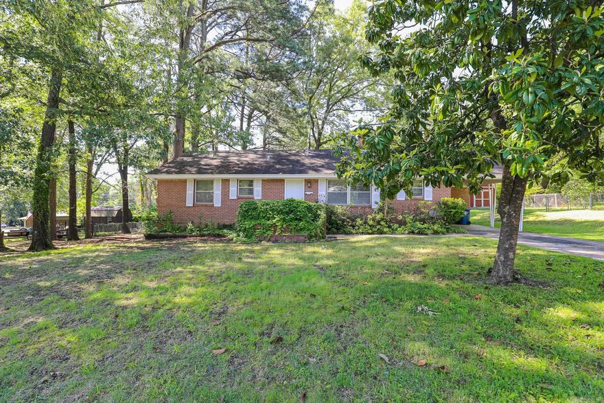 Brick Home on 2.5  city lots. 3 bedroom 2 bath. Living area w/wbfp.  Separate Dining area. Ceramic tile floors in wet areas and beautiful light wood floors in all other rooms. Primary bath has been updated with tile shower. new toilet in both baths.  New front door. 1 car carport w/ storage room. Also has a large storage building.  Huge tree covered lots. Fenced.  This home is close to shopping, dining and schools. This is a great home under $175,000.  New Roof being installed prior to closing. See agent remarks!