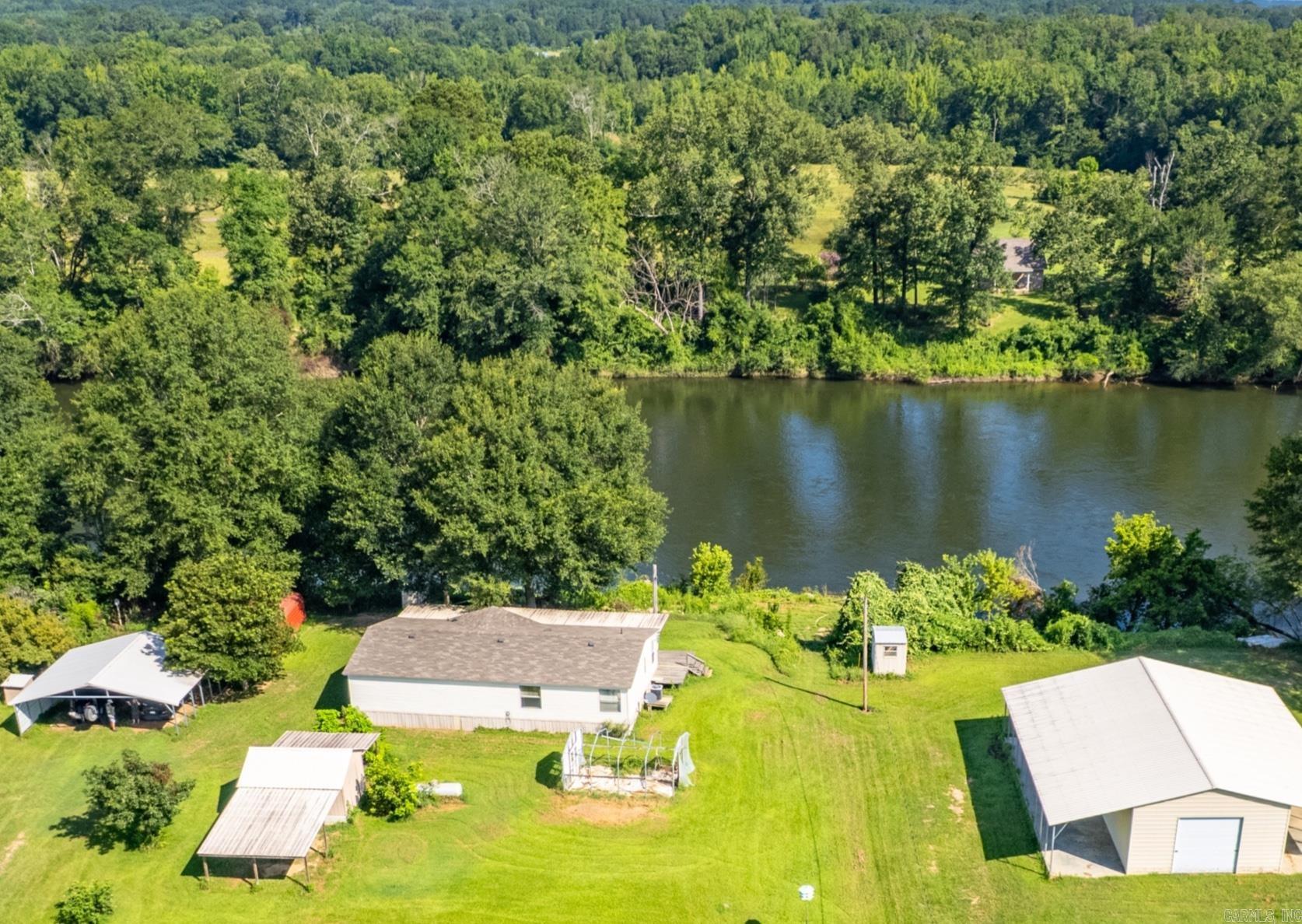 Welcome to your own slice of serenity! Set on approximately 8.29 acres, this charming 3-bedroom, 2-bath home offers the best of both worlds—tranquil riverfront living and quick access to the interstate for all the conveniences of town. Enjoy the freedom of wide-open space, garden-ready land, and the beauty of nature right outside your door. The home provides cozy, functional living, while the shop with a half bath is perfect for creative projects, a small business, or extra storage. Plus, additional outbuildings add even more flexibility to suit your lifestyle. Whether you're dreaming of a peaceful homestead, a relaxing weekend escape, or a live/work opportunity in a scenic setting, this unique property delivers! Don’t miss your chance to make this riverside retreat your own.