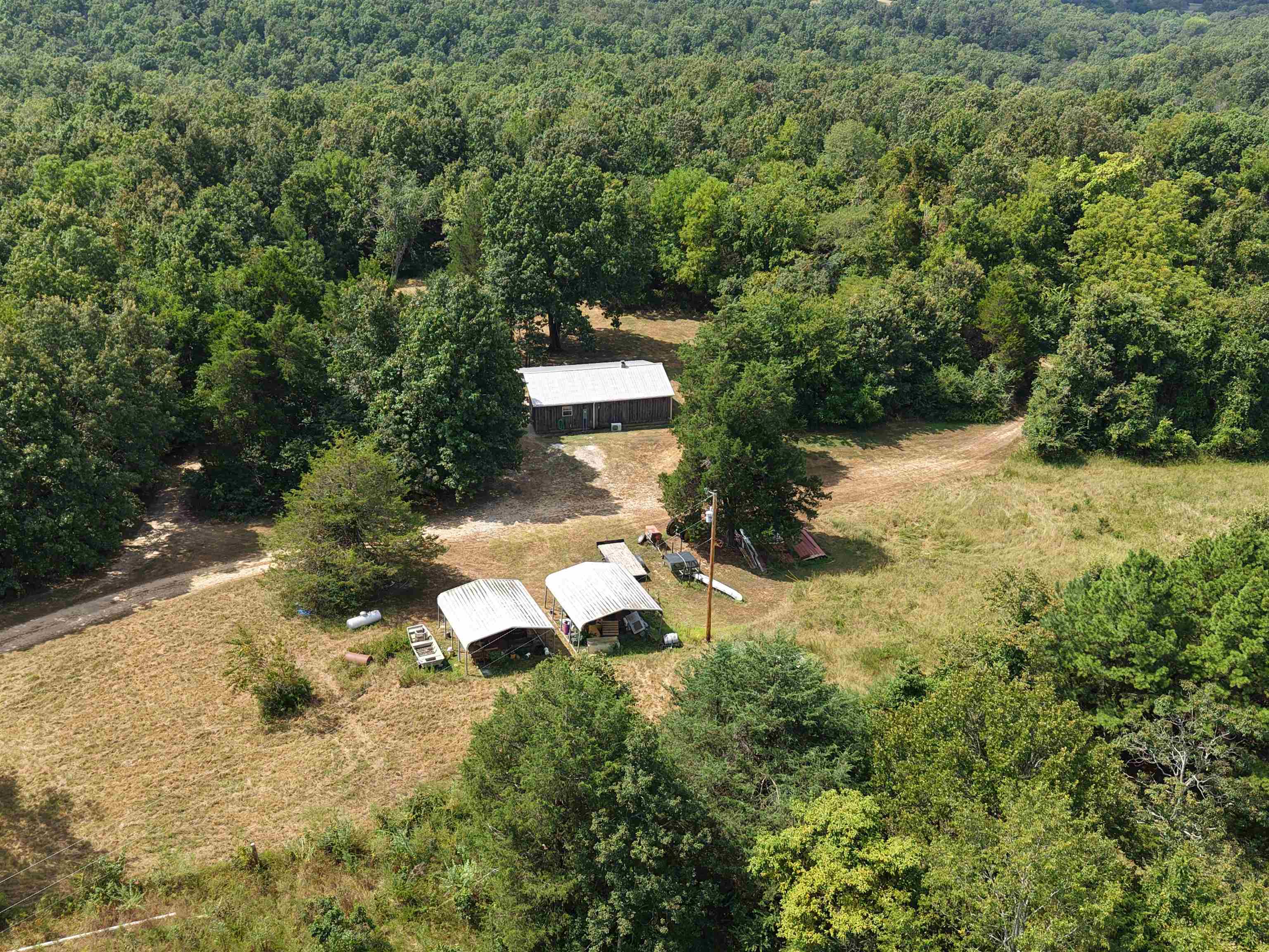Featuring a charming 2-bedroom, 1-bathroom cabin, this 70 acre property is nestled among mature trees and teeming with wildlife. The location is just minutes from the Spring River, Mammoth Spring, Arkansas, and Thayer, Missouri—keeping you close to small-town charm, restaurants, and shopping. It is a true hunting and fishing paradise, offering multiple food plots, ponds, and a fully fenced perimeter. Whether you’re tracking deer at dawn or casting a line at sunset, every day here is an adventure. This property is also highlighted by a spectacular hand-laid rock fireplace outside that sets the tone for cozy evenings after a day in the field. A recently installed water well also adds modern convenience. Perfect as a weekend escape or a year-round haven, this property blends comfort, seclusion, and recreation in one unforgettable package, all for $319,900.