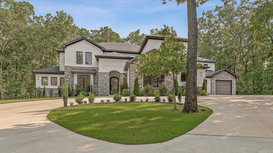 A rare offering in the prestigious RidgePointe community — this exceptional 2-year-old estate is gracefully poised on 3.22 acres of pristine, private grounds. Perfectly blending seclusion with convenience, it’s just a short golf cart ride to the RidgePointe Country Club. The moment you cross the threshold, soaring ceilings and expansive walls of glass unveil panoramic views of the serene, wooded landscape. The great room’s dramatic two-story, floor-to-ceiling tiled fireplace serves as a breathtaking focal point, while the chef’s kitchen boasts Quartz countertops, a hidden walk-in pantry, premium KitchenAid appliances, and a 5-burner gas cooktop. The palatial primary suite offers a spa-inspired bath with a soaking tub, a huge tiled walk in shower, and an extraordinary boutique-style closet with an island. Additional luxuries include four guest suites, a safe room with ventilation and Wi-Fi, five garage stalls, and designer finishes throughout. Outdoors, the heated saltwater pool with tanning ledge shimmers under the sun, embraced by wrought iron fencing, lush landscaping, and dramatic evening lighting. Seize this rare opportunity to claim your own private country club retreat!