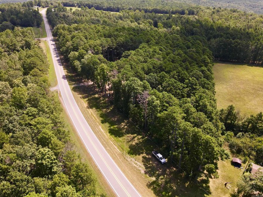 If you’re searching for unrestricted land for sale in Arkansas with utilities in place and prime highway frontage, this one checks every box. Situated along a state highway with approximately 825 feet of road frontage, this build-ready parcel offers convenience, natural beauty, and long-term potential. The gently sloping terrain is graced with tall pines for privacy, while the center of the property is already cleared and leveled - perfect for your dream home, cabin, or weekend retreat.