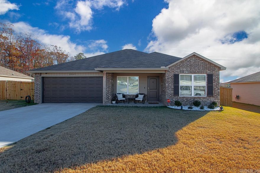 This delightful 4-bedroom, 2-bathroom home in the serene Hilldale Crossing neighborhood features a privacy-oriented split floor plan with open concept living. The eat-in kitchen, equipped with a bar top, invites family gatherings and informal meals, while the entire space enjoys Luxury Vinyl Plank flooring for a modern aesthetic.  The master bedroom is strategically placed at the rear for added privacy. Out back, a charming 14x10 wood deck provides an excellent space for entertaining and relaxation. The property also boasts a new privacy fence, enhancing both security and seclusion.  Upgrades include a deep kitchen sink, enhanced plumbing fixtures, Cheyenne-style interior doors, and premium baseboards. The kitchen is fitted with a smooth top range and a built-in microwave hood, ensuring functionality matches style.  Located conveniently near HWY 5 and the HWY 30/430 interchange, the home is just a short drive from the Outlets of Little Rock and Bass Pro, combining suburban tranquility with easy access to local amenities.  Discover comfortable living at 2263 Bentwood Drive—a perfect blend of style and convenience.